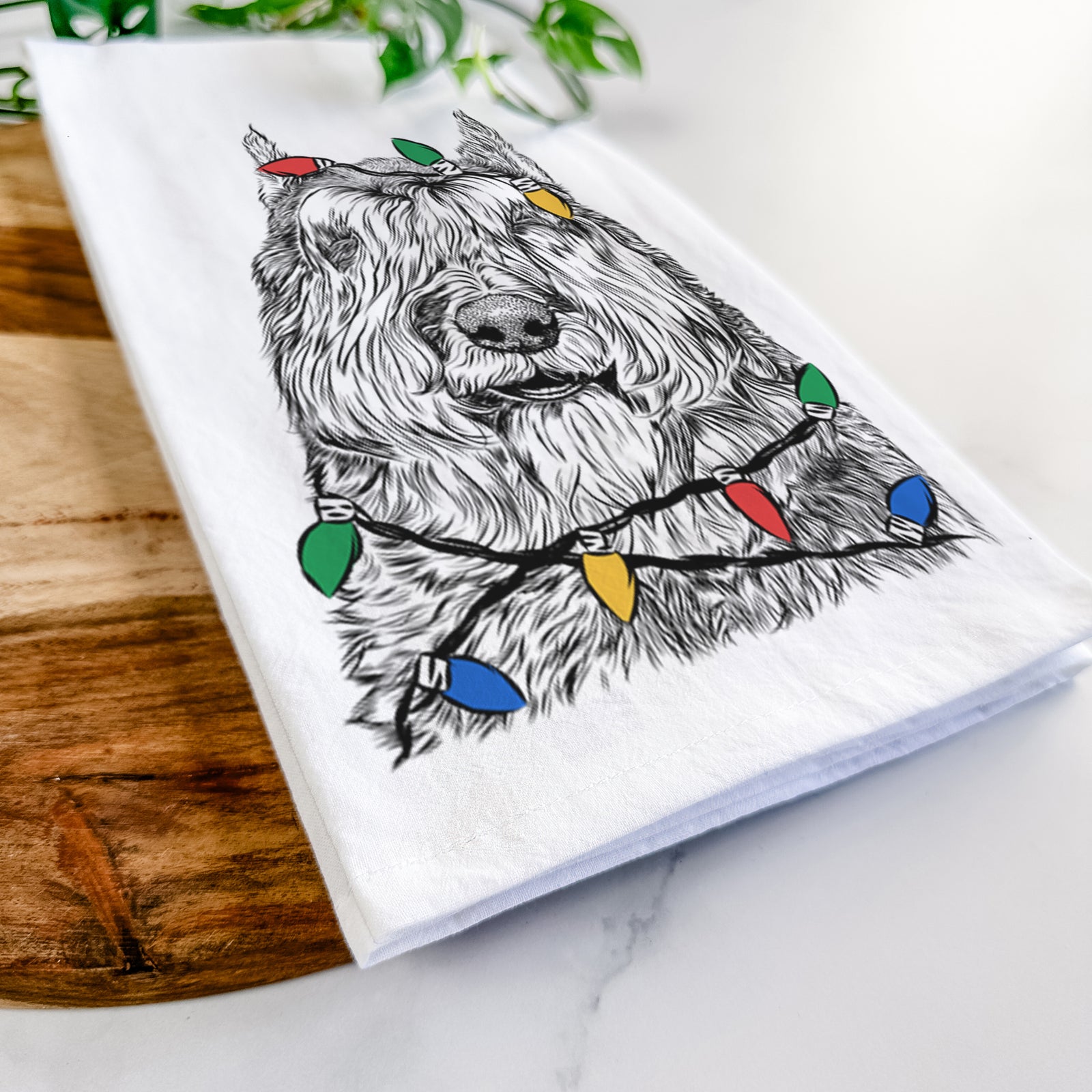 Hand-drawn sketch of Sabre the Bouvier Des Flandres wrapped in Christmas lights on a tea towel
