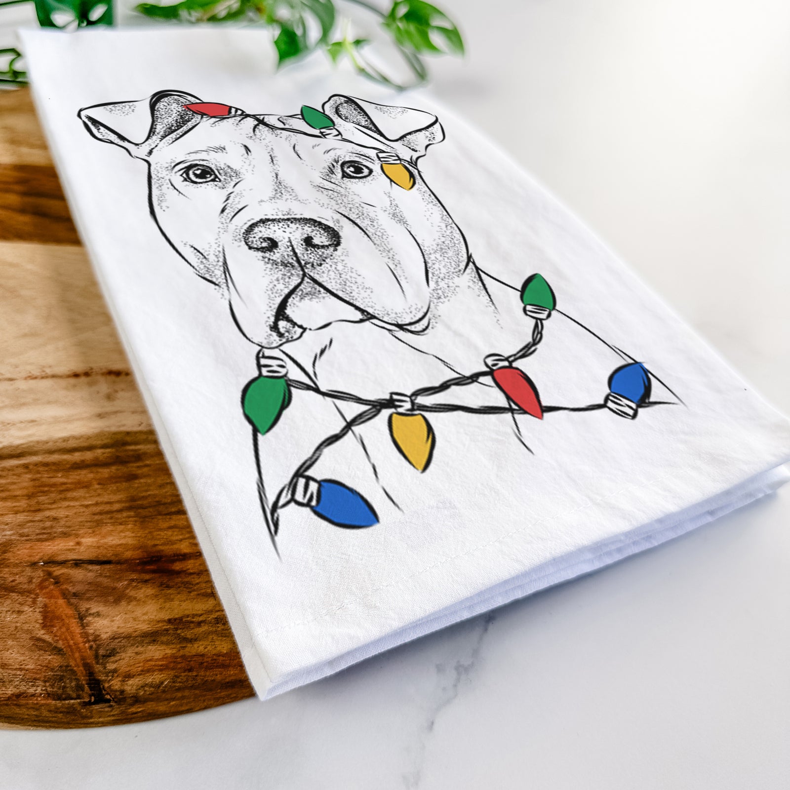 Hand-drawn sketch of Scraps the American Staffordshire Mix wrapped in Christmas lights on a tea towel