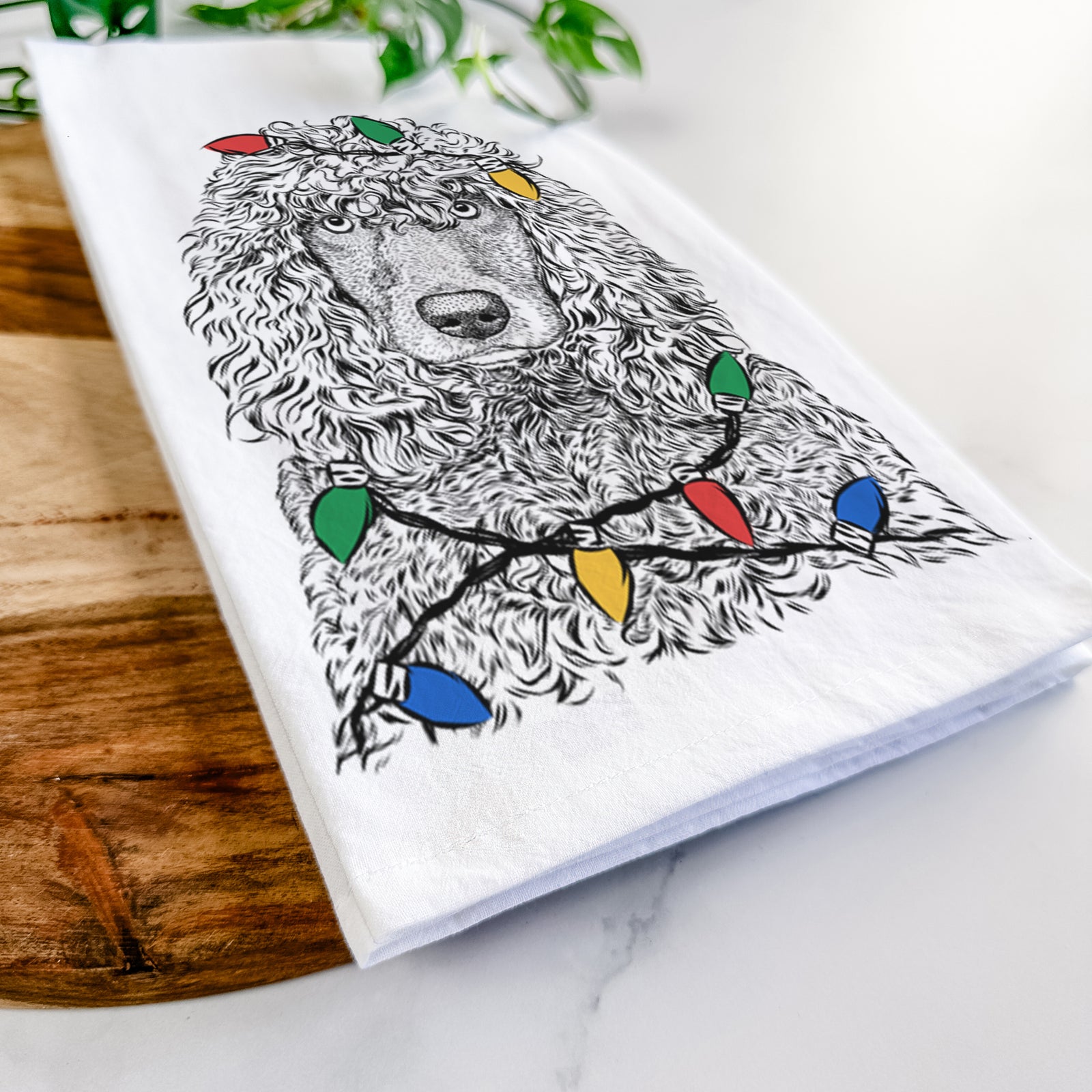 Hand-drawn sketch of Shilo the Irish Water Spaniel wrapped in Christmas lights on a tea towel