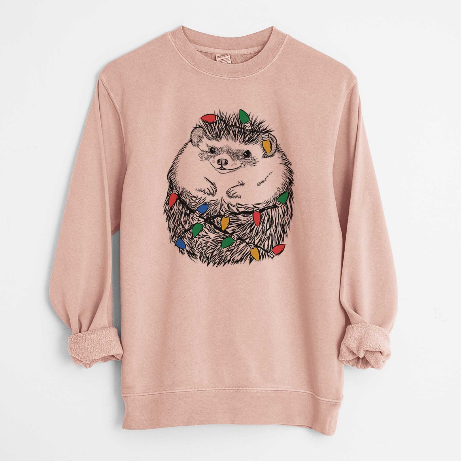 Hand-drawn sketch of Sid the Hedgehog wrapped in Christmas lights on a Dusty Pink Unisex pigment dyed crew sweatshirt