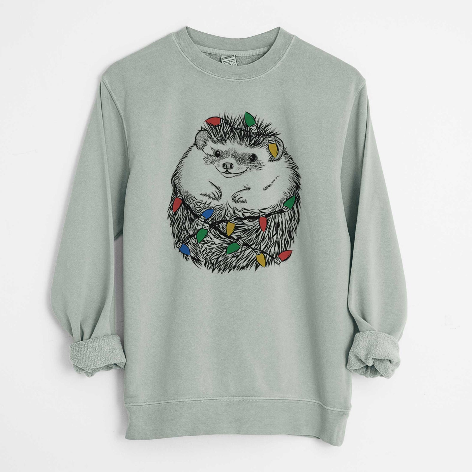 Hand-drawn sketch of Sid the Hedgehog wrapped in Christmas lights on a Sage Unisex pigment dyed crew sweatshirt