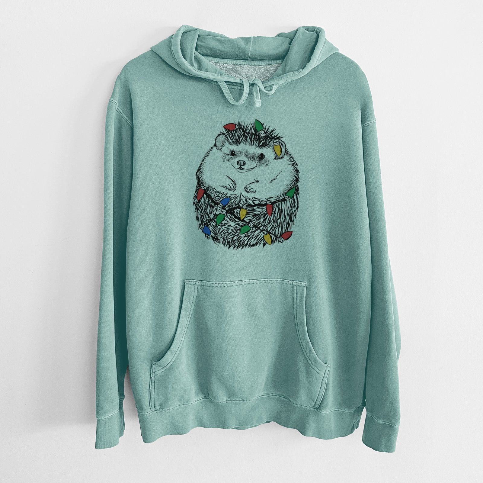 Hand-drawn sketch of Sid the Hedgehog wrapped in Christmas lights on a Mint Unisex pigment dyed hoodie