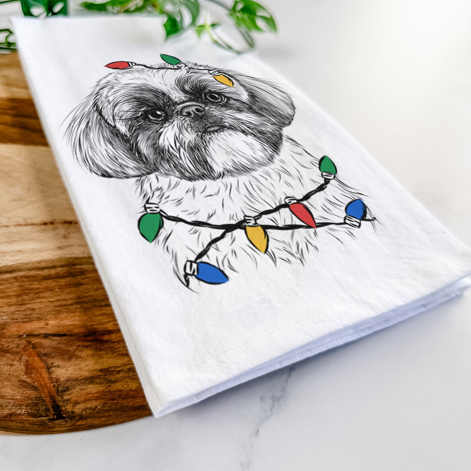 Hand-drawn sketch of Simon the Shih Tzu wrapped in Christmas lights on a tea towel