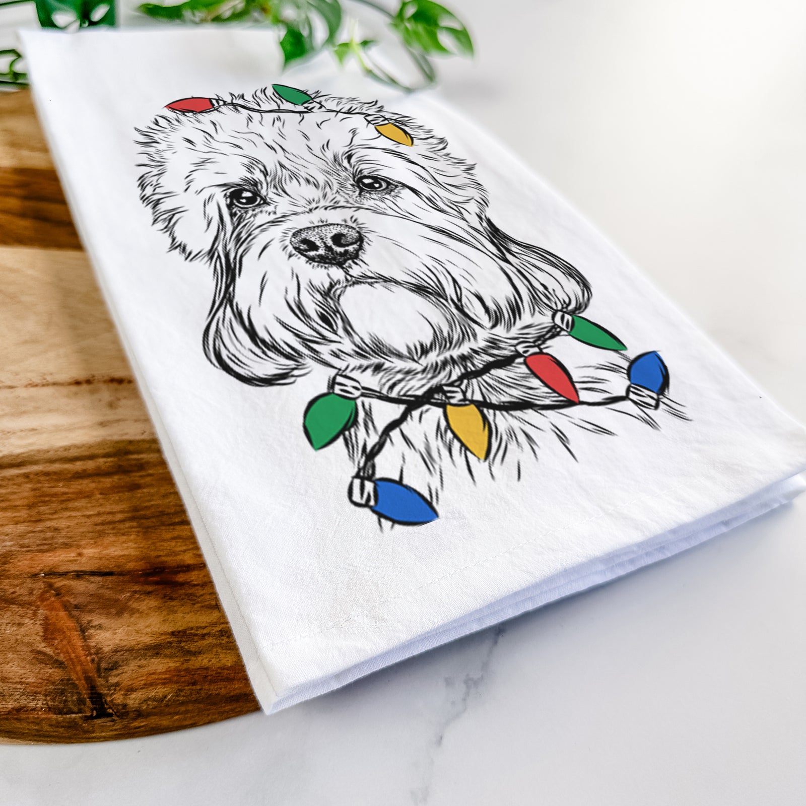 Hand-drawn sketch of Sir Walter the Dandie Dinmont Terrier wrapped in Christmas lights on a tea towel