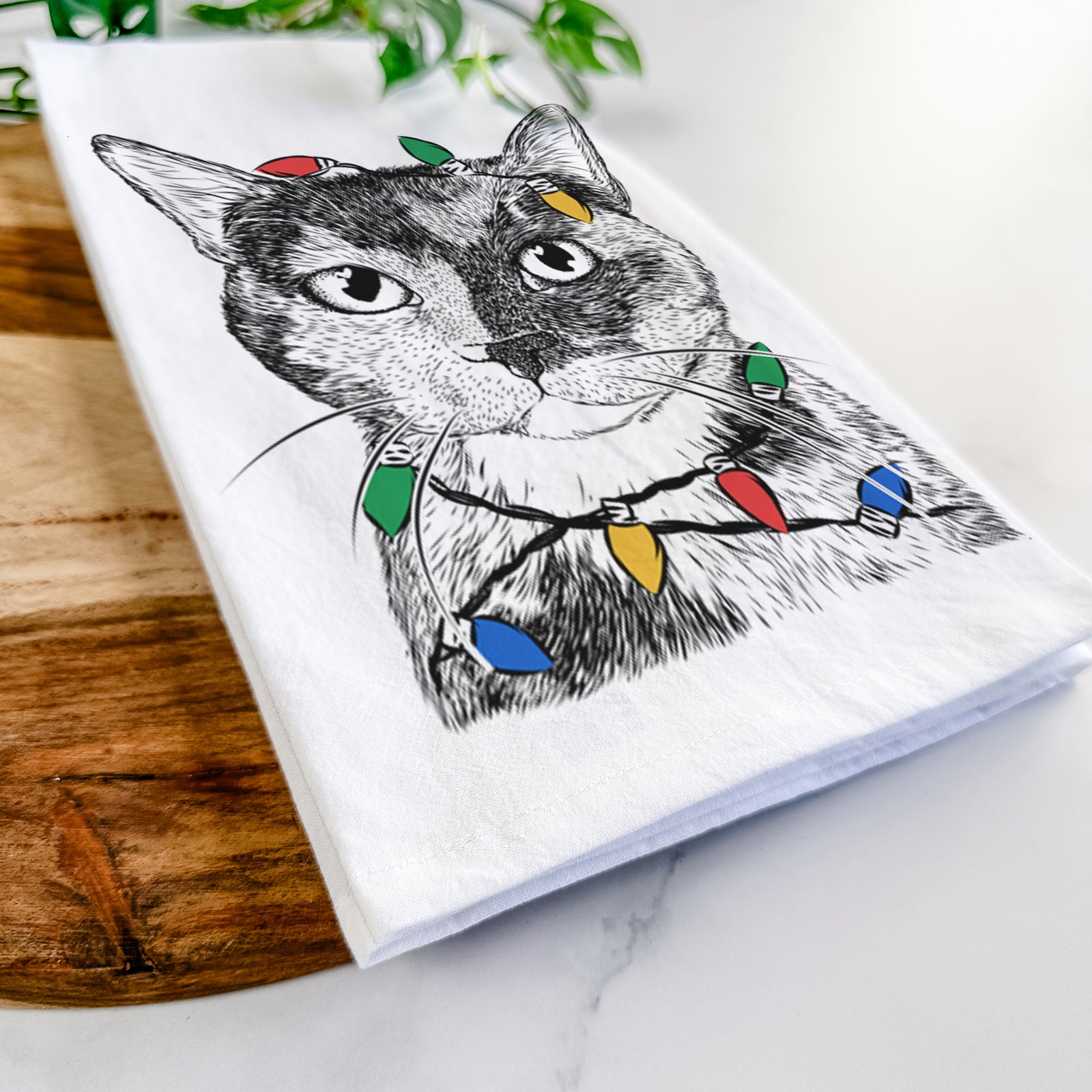 Hand-drawn sketch of Spooky Kitty the Tortoiseshell Cat wrapped in Christmas lights on a tea towel