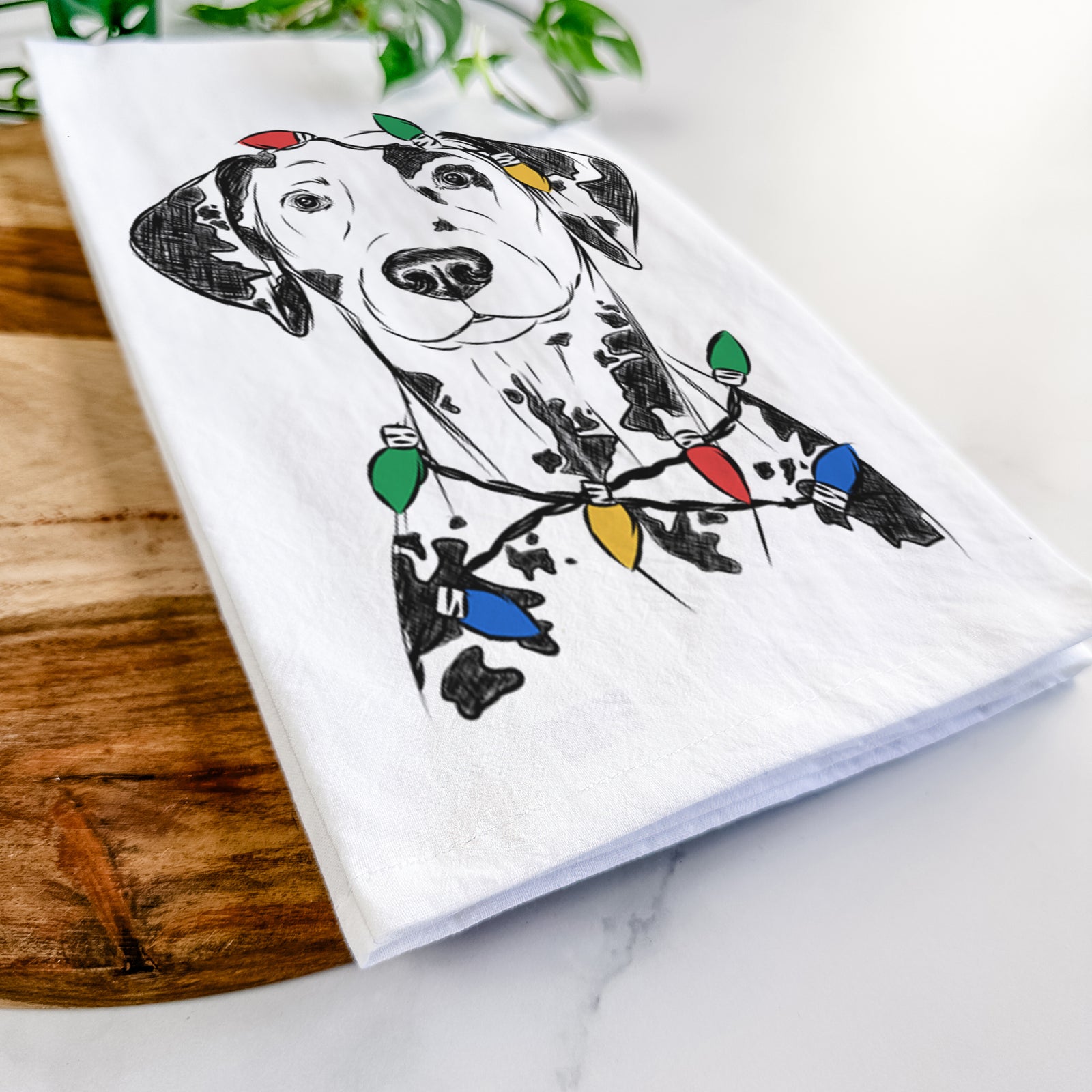 Hand-drawn sketch of Spot the Dalmatian wrapped in Christmas lights on a tea towel