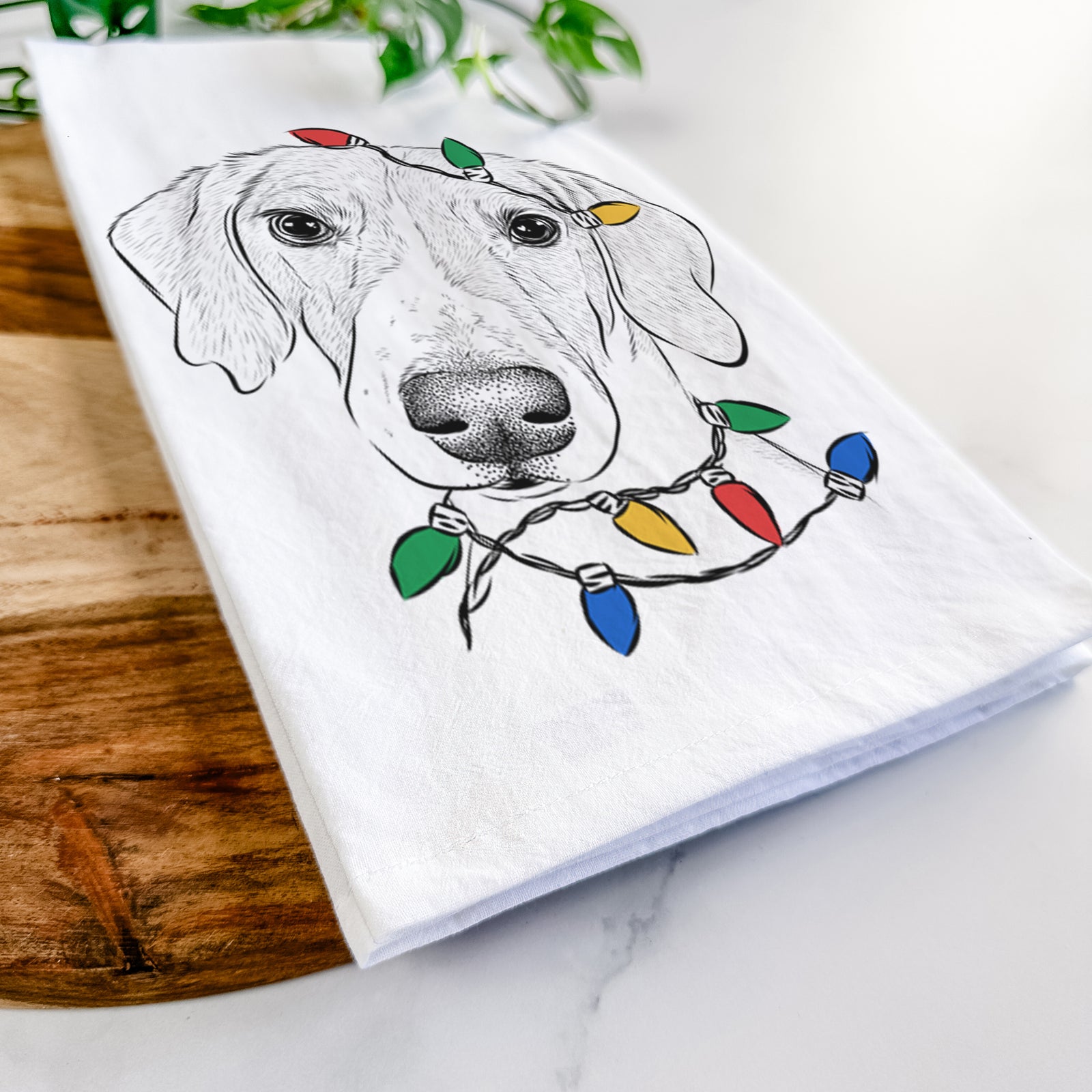Hand-drawn sketch of Stanley the Foxhound wrapped in Christmas lights on a tea towel