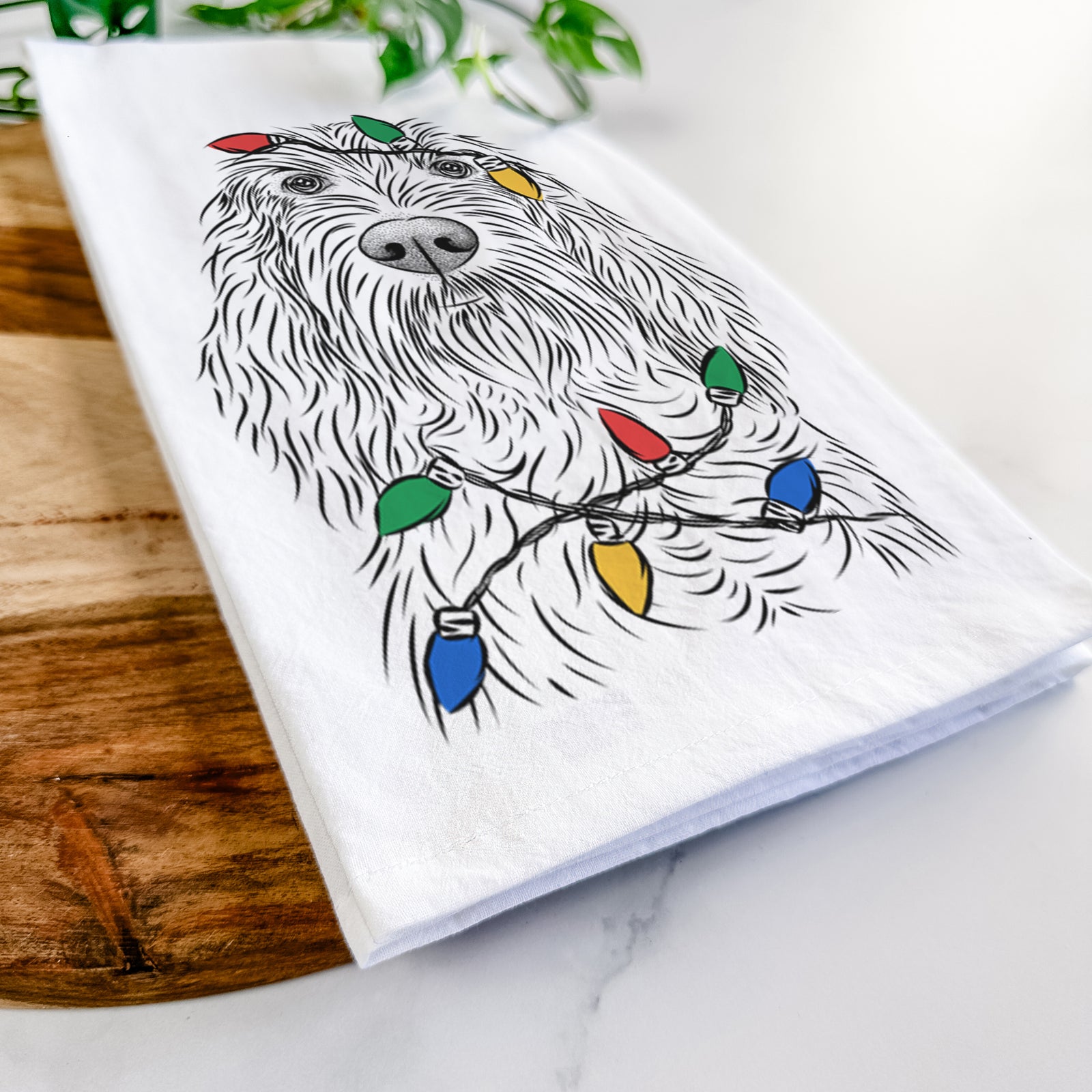 Hand-drawn sketch of Stefano the Spinone Italiano wrapped in Christmas lights on a tea towel