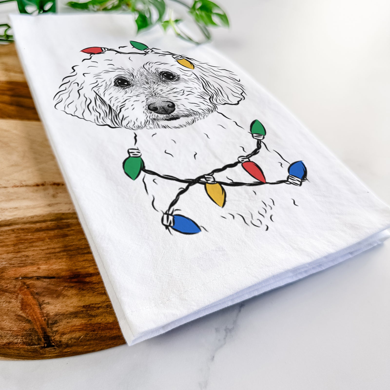 Hand-drawn sketch of Stitch the Bichonpoo wrapped in Christmas lights on a tea towel