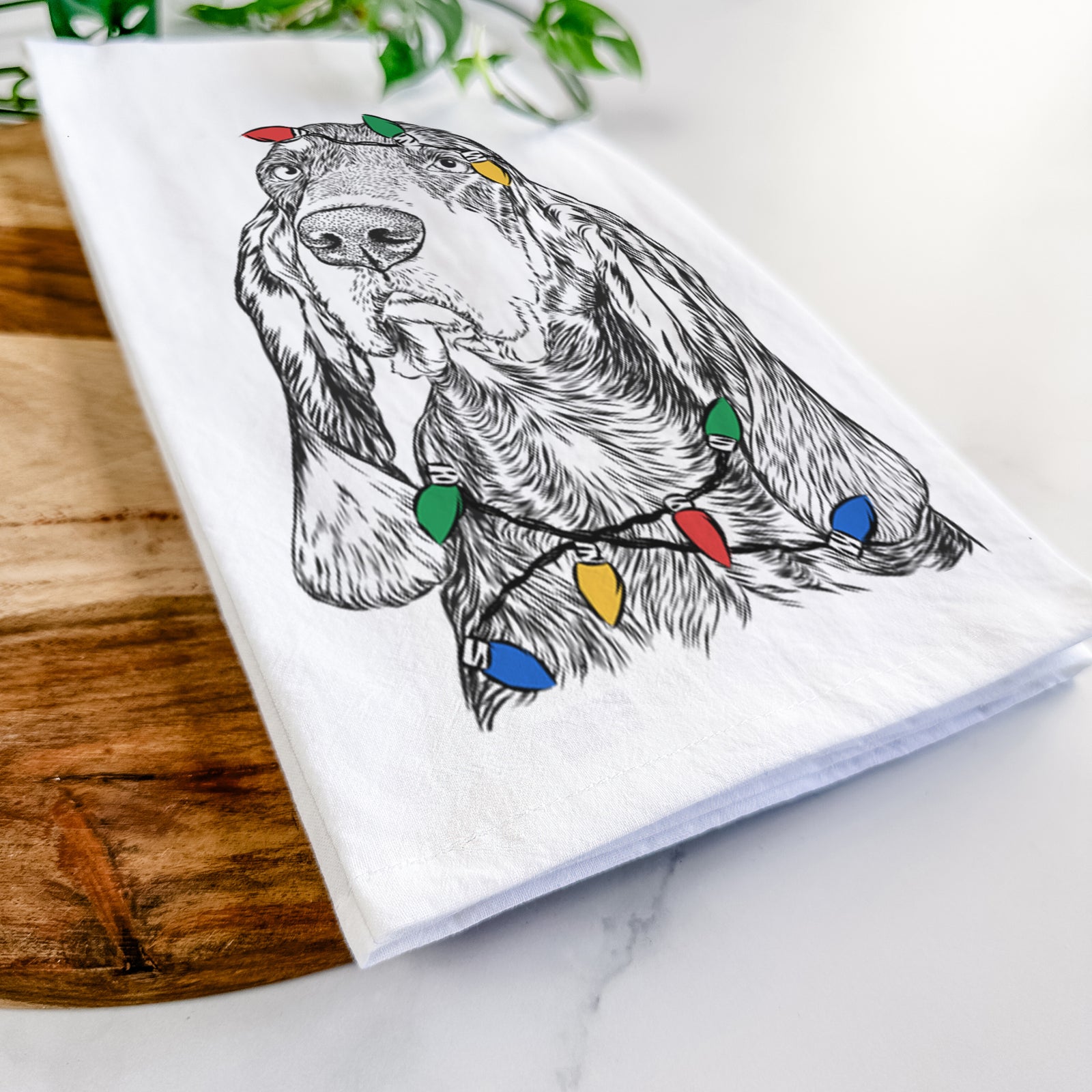 Hand-drawn sketch of Stu the Black and Tan Coonhound wrapped in Christmas lights on a tea towel