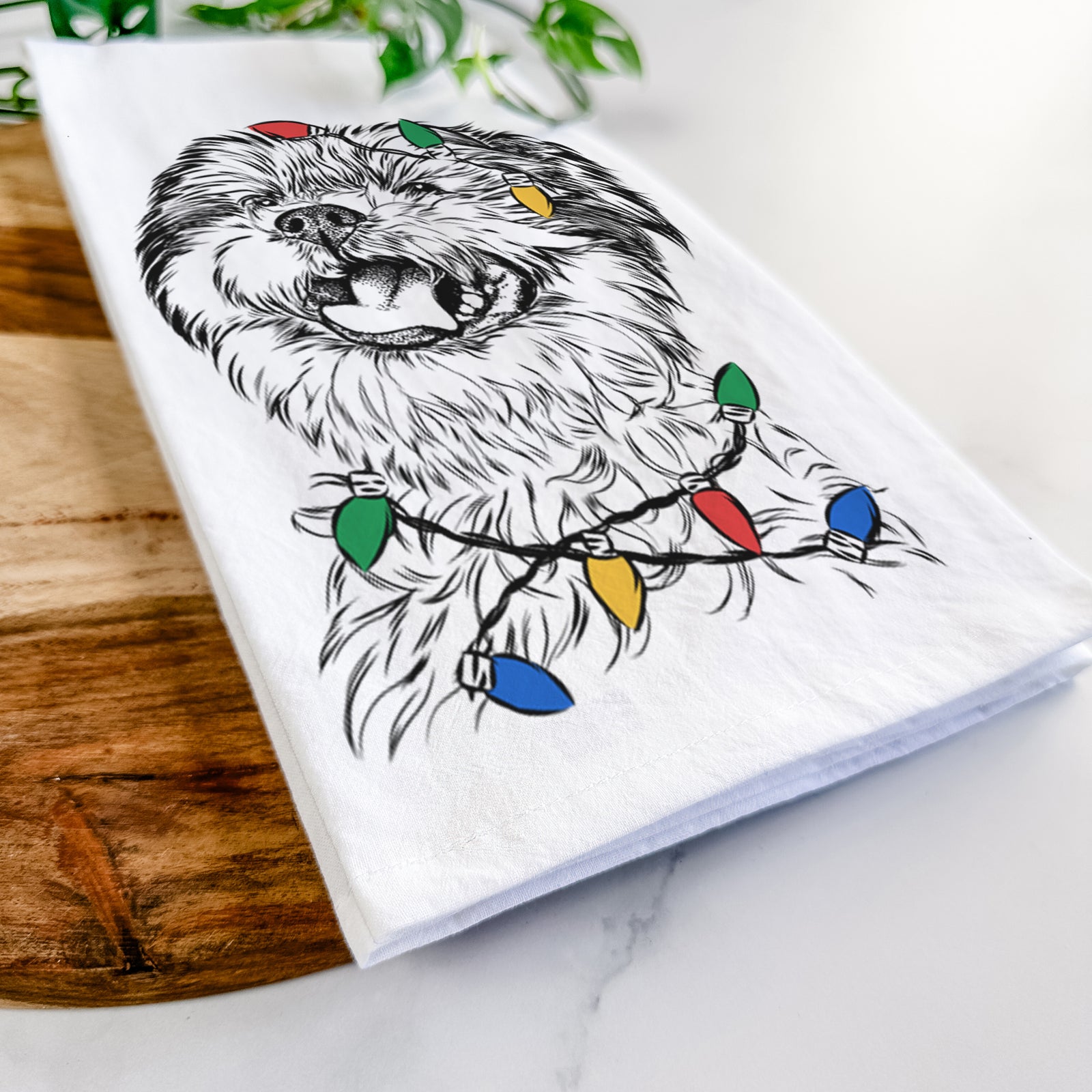 Hand-drawn sketch of Sugar the Malshi wrapped in Christmas lights on a tea towel