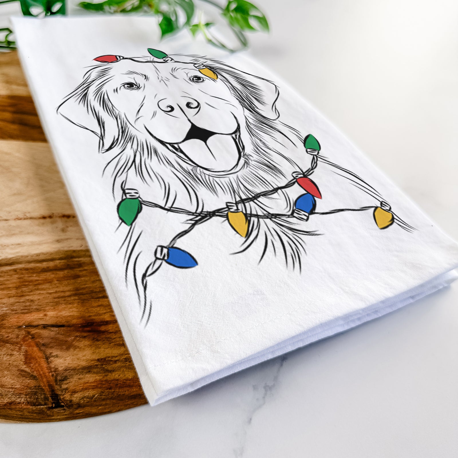 Hand-drawn sketch of Sunny the Golden Retriever wrapped in Christmas lights on a tea towel