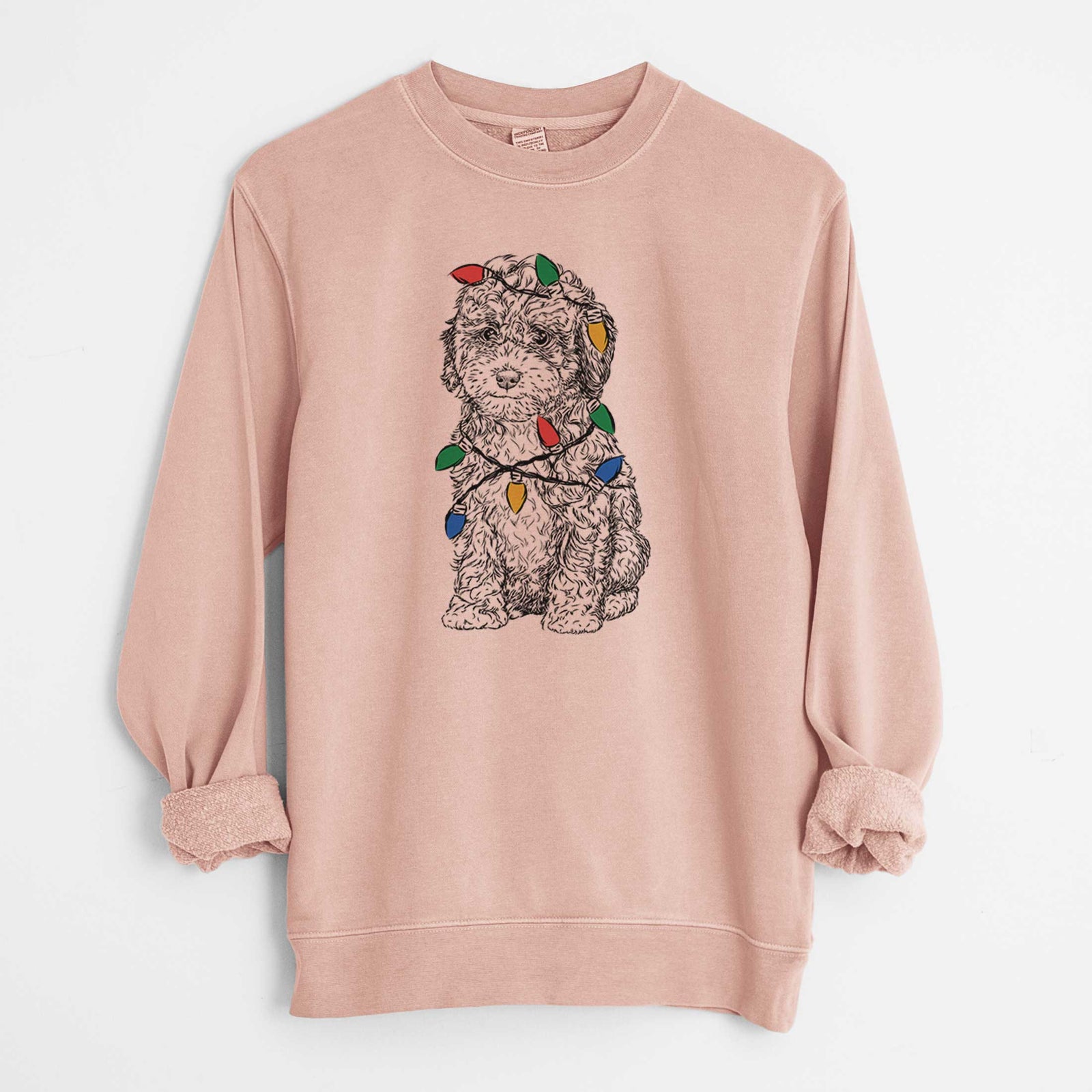 Hand-drawn sketch of Sweet Tea the Mini Doodle wrapped in Christmas lights on a Dusty Pink Unisex pigment dyed crew sweatshirt