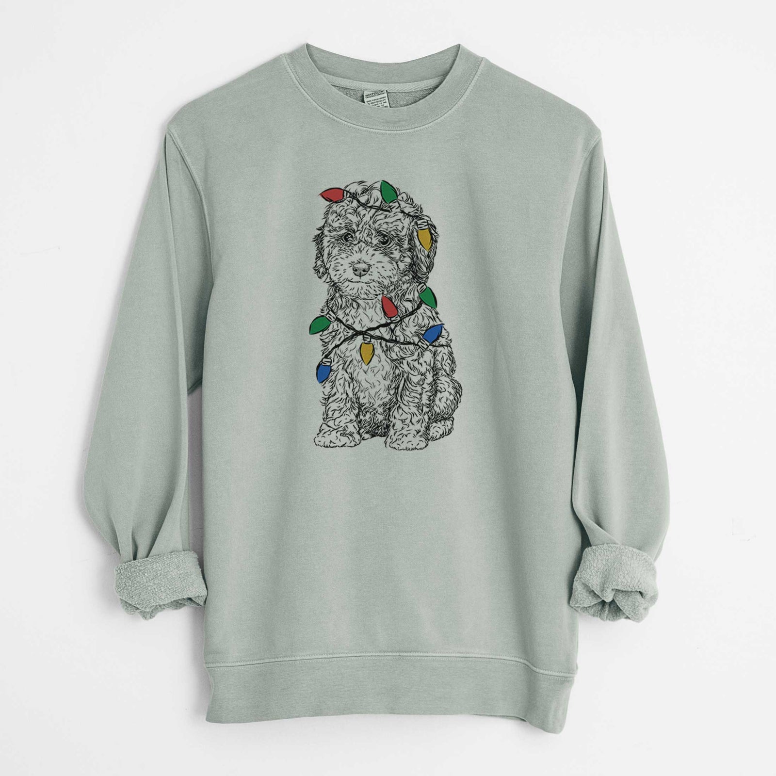 Hand-drawn sketch of Sweet Tea the Mini Doodle wrapped in Christmas lights on a Sage Unisex pigment dyed crew sweatshirt