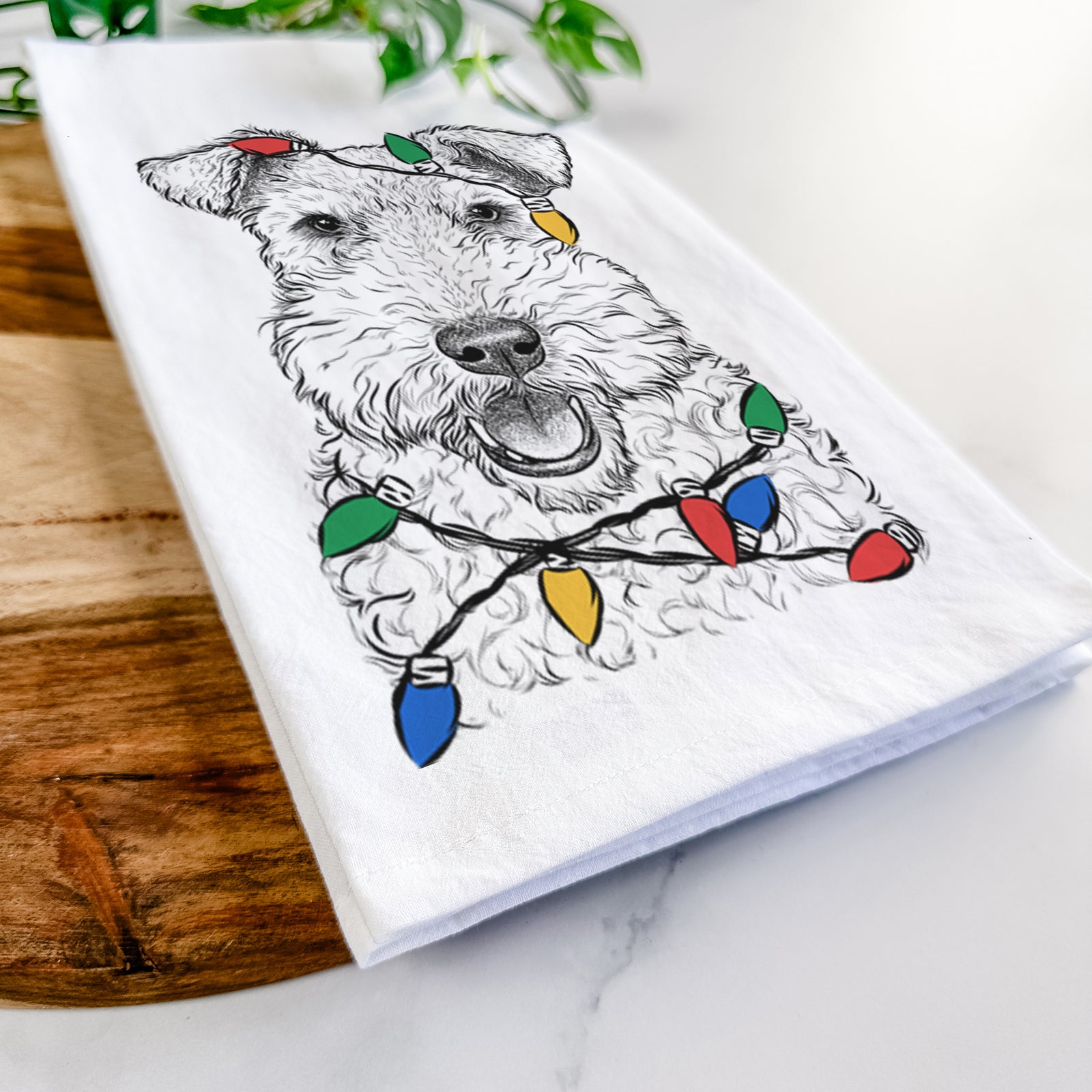 Hand-drawn sketch of Ted the Wire Fox Terrier wrapped in Christmas lights on a tea towel