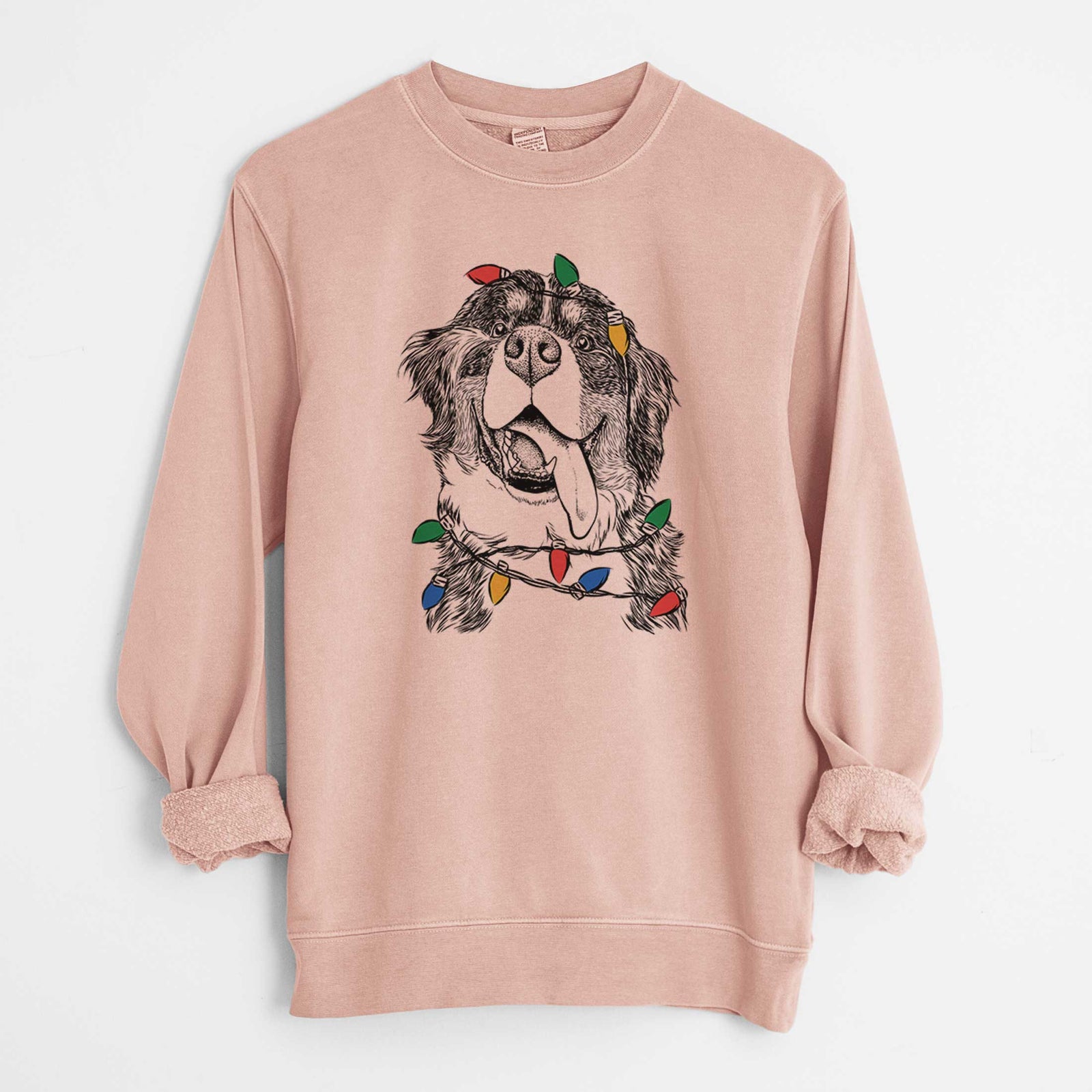 Hand-drawn sketch of Theo the Bernese Mountain Dog wrapped in Christmas lights on a Dusty Pink Unisex pigment dyed crew sweatshirt