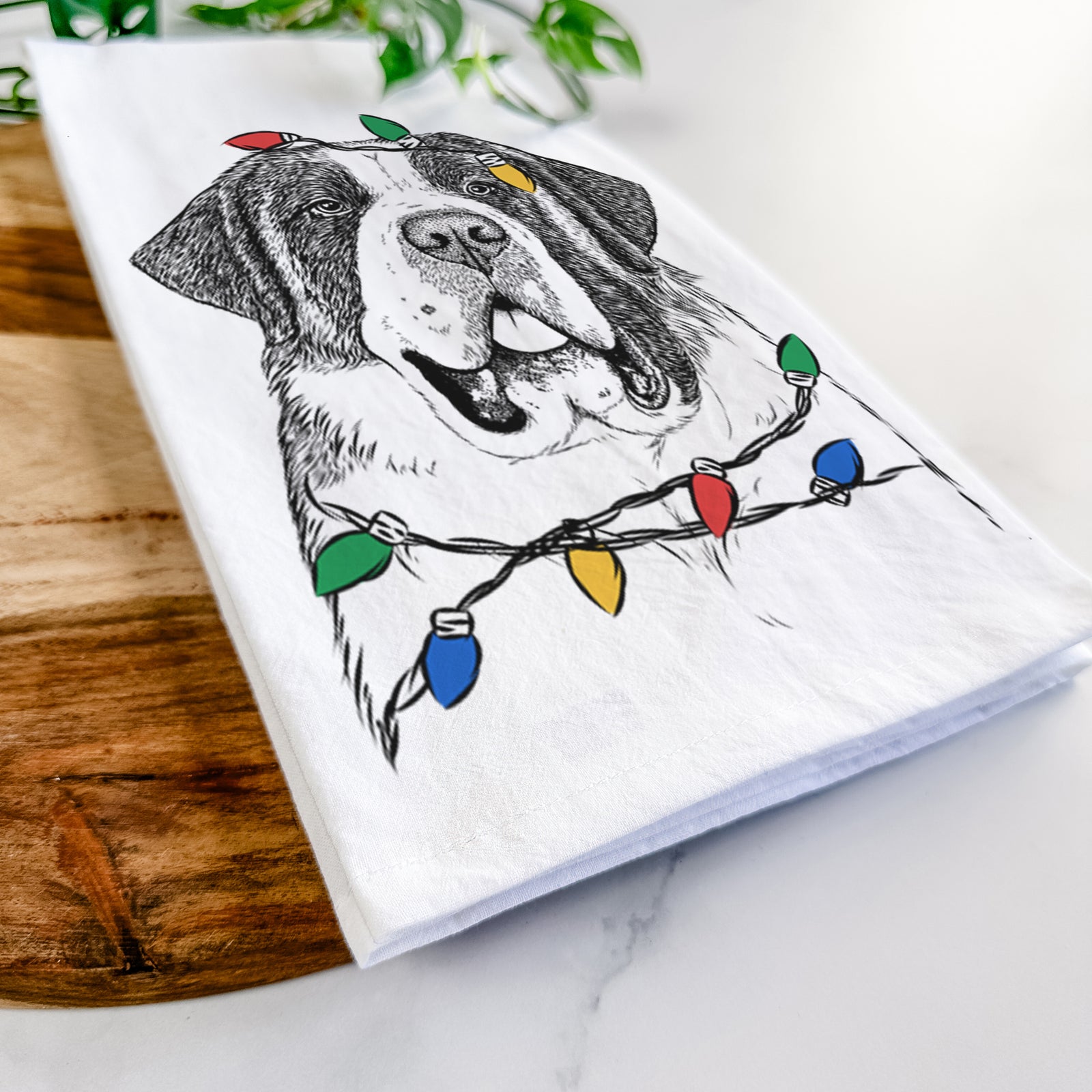 Hand-drawn sketch of Thor the Saint Bernard wrapped in Christmas lights on a tea towel