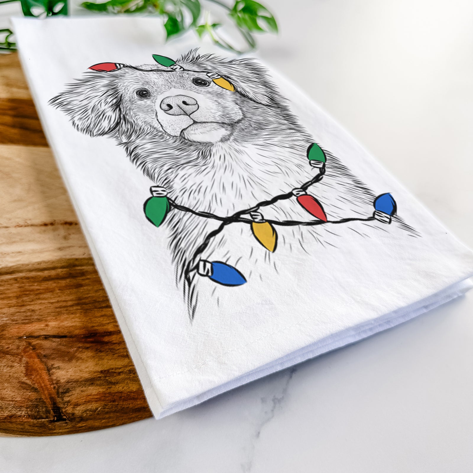 Hand-drawn sketch of Vixen the Nova Scotia Duck Tolling Retriever wrapped in Christmas lights on a tea towel