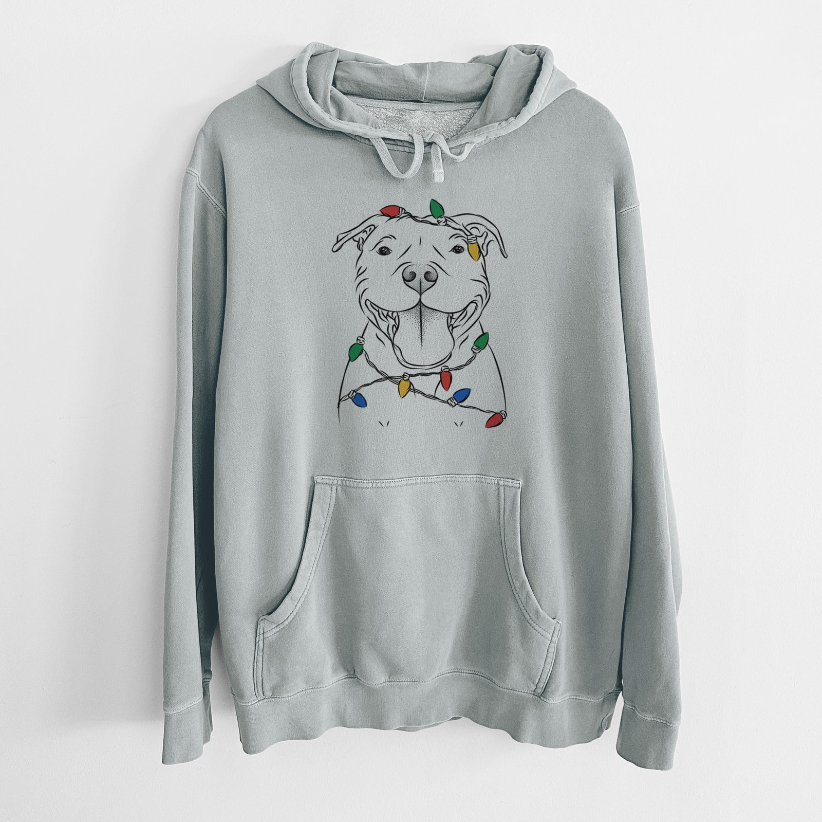Hand-drawn sketch of Wafer the Staffordshire Bull Terrier wrapped in Christmas lights on a Sage Unisex pigment dyed hoodie