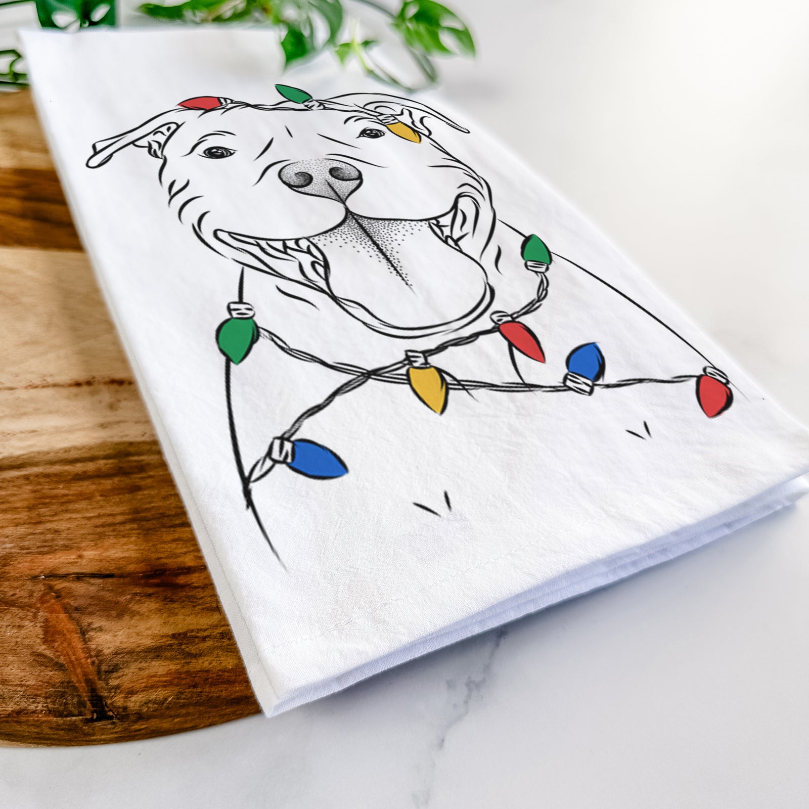 Hand-drawn sketch of Wafer the Staffordshire Bull Terrier wrapped in Christmas lights on a tea towel