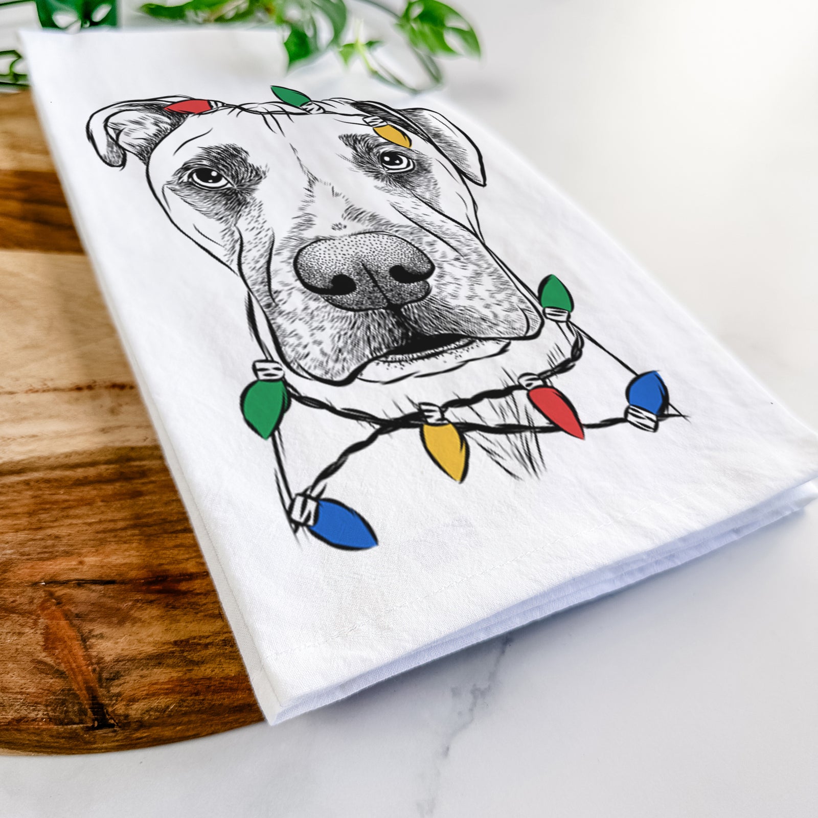 Hand-drawn sketch of Waylon the Boxane wrapped in Christmas lights on a tea towel