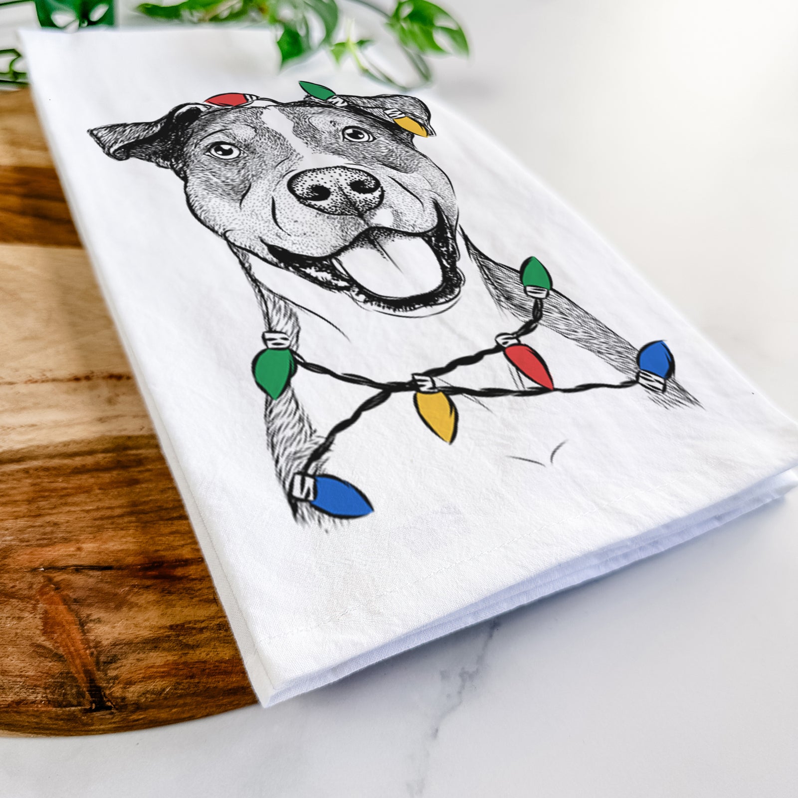 Hand-drawn sketch of Wendy the Mixed Breed wrapped in Christmas lights on a tea towel