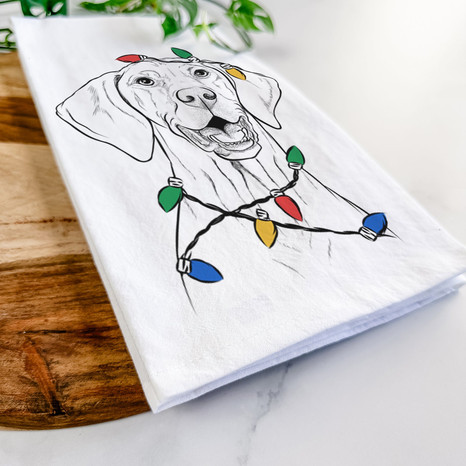 Hand-drawn sketch of Wesley the Vizsla wrapped in Christmas lights on a tea towel