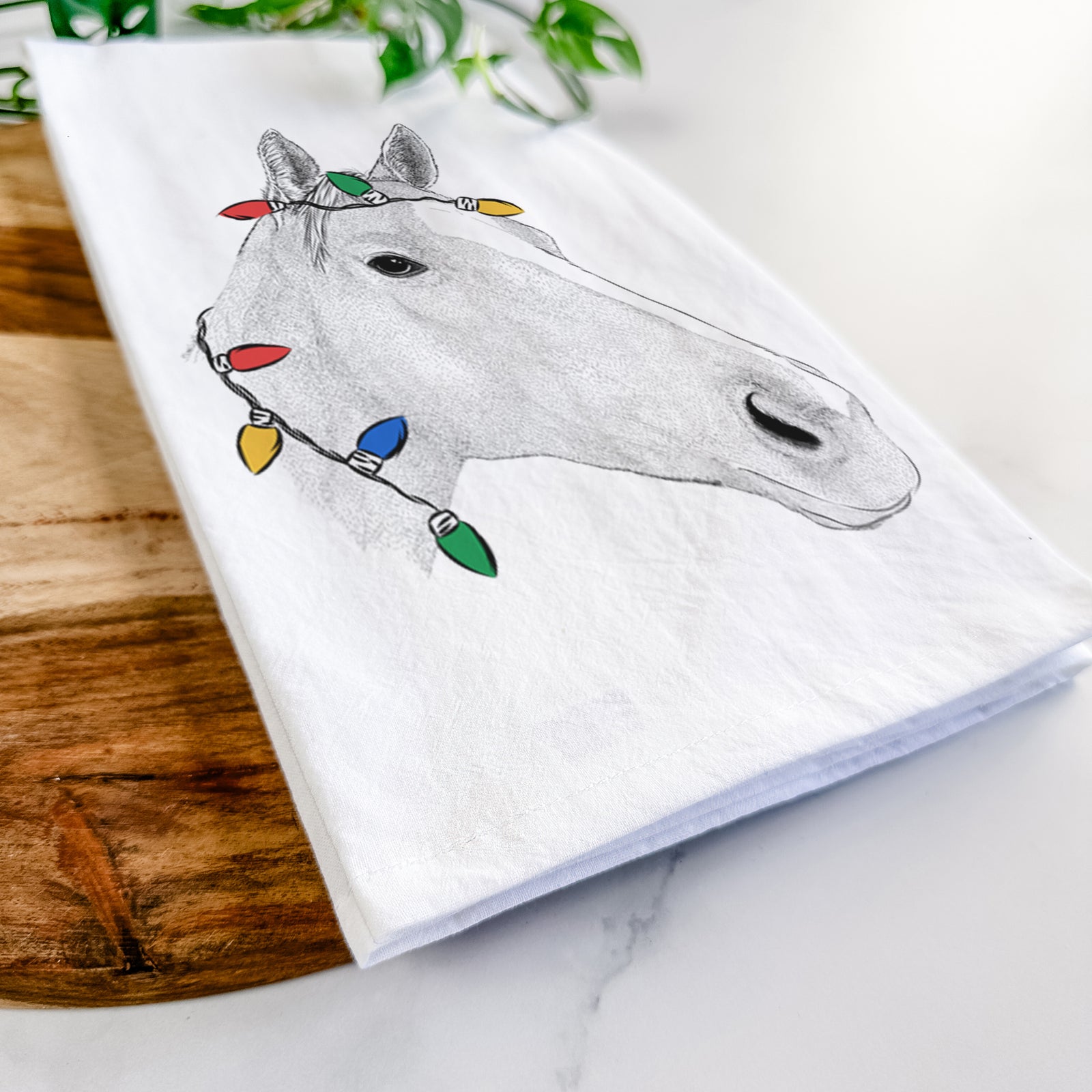 Hand-drawn sketch of Westley the Horse wrapped in Christmas lights on a tea towel