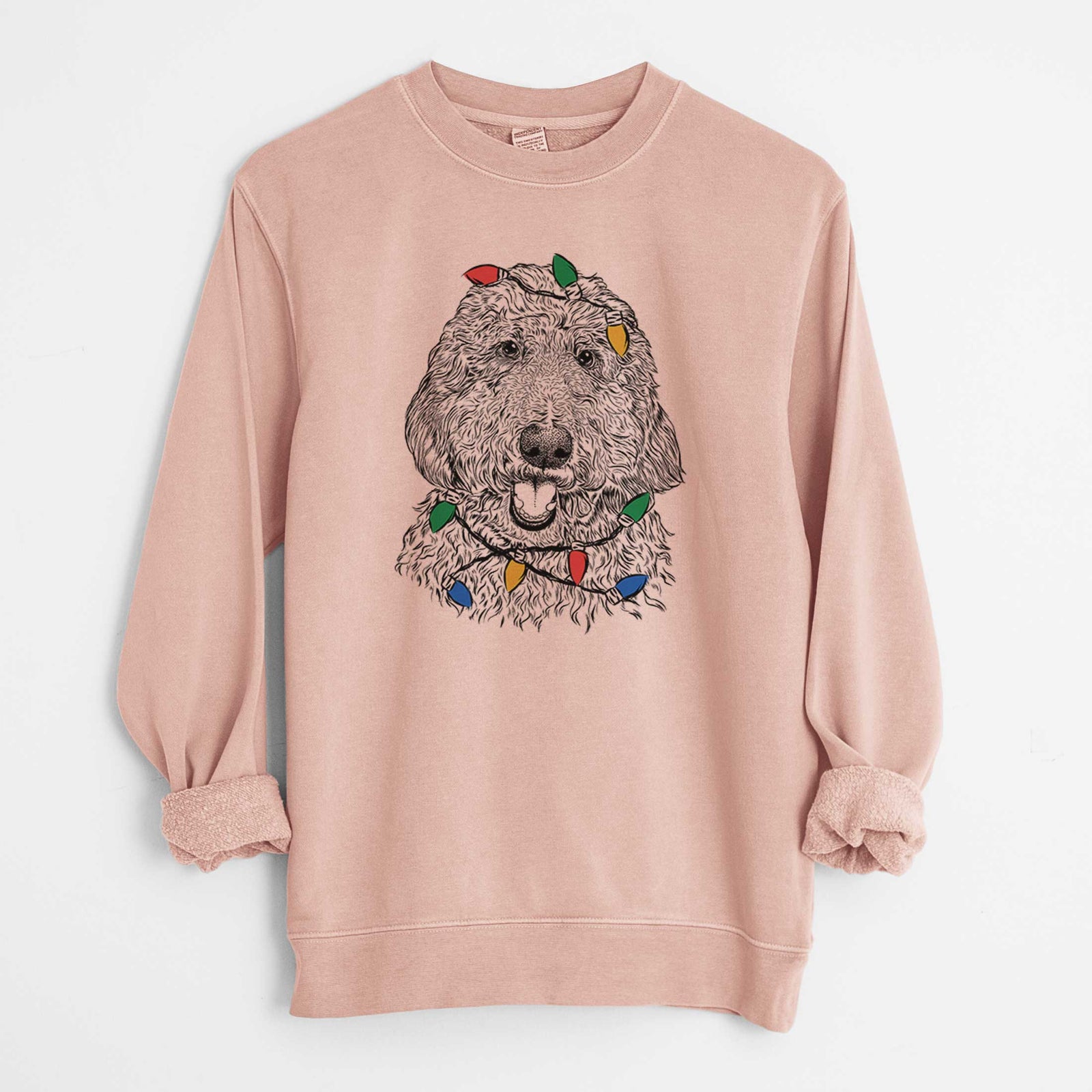 Hand-drawn sketch of Whisper the Goldendoodle wrapped in Christmas lights on a Dusty Pink Unisex pigment dyed crew sweatshirt