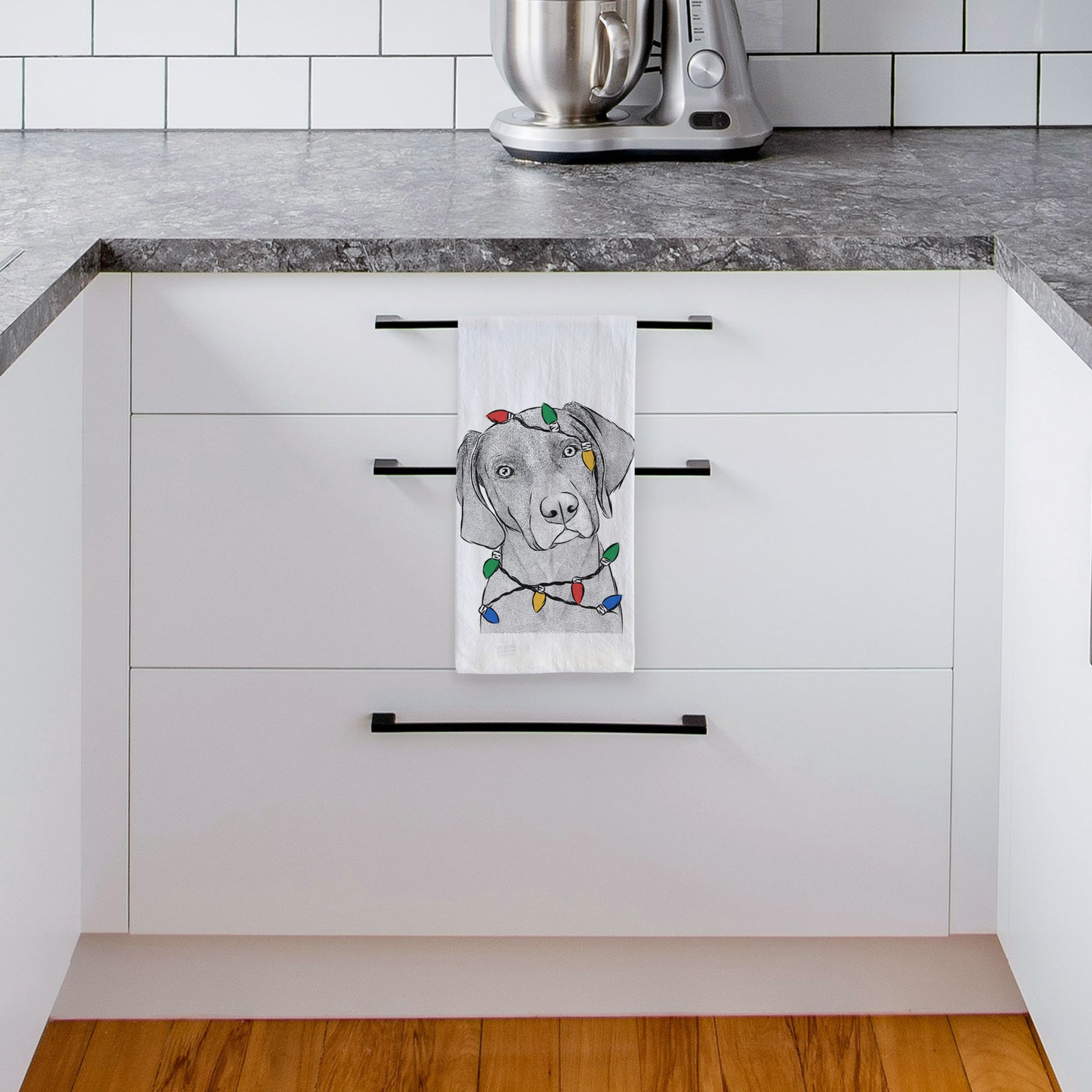 Hand-drawn sketch of Willow the Weizsla wrapped in Christmas lights on a tea towel, hanging on an oven door in a kitchen
