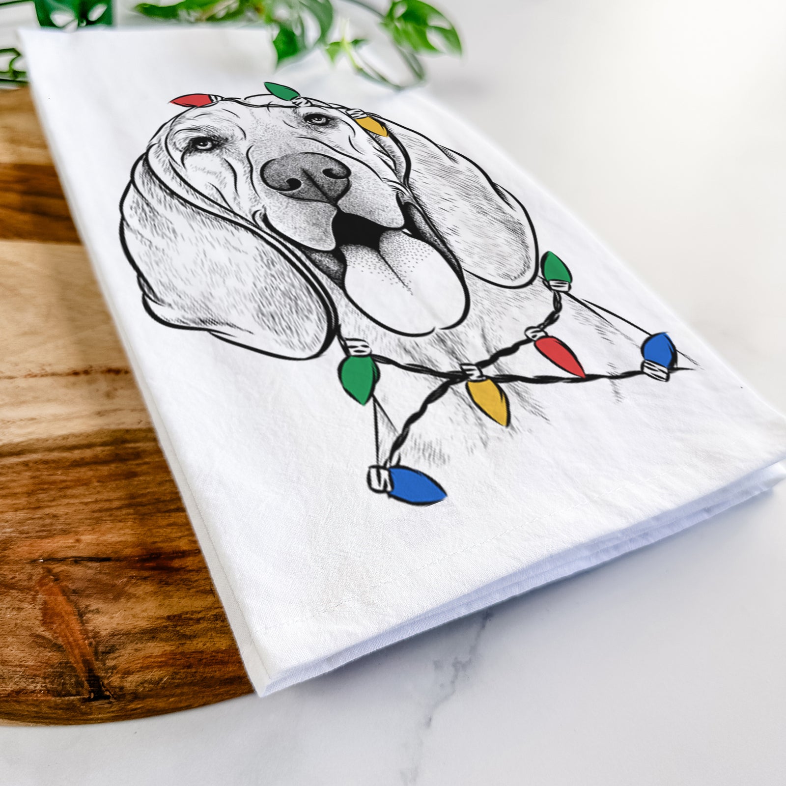 Hand-drawn sketch of Winston the Redbone Coonhound wrapped in Christmas lights on a tea towel