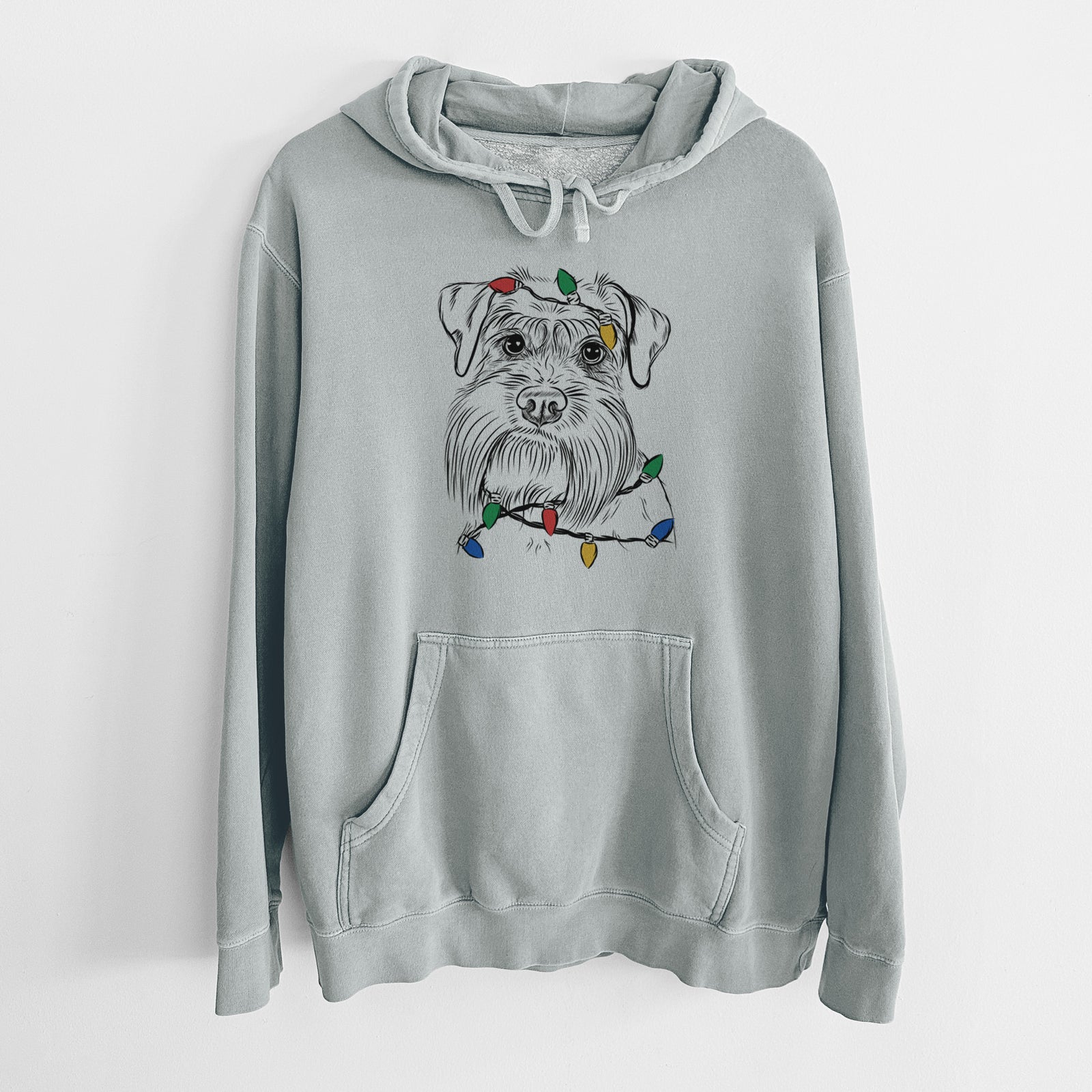 Hand-drawn sketch of Wrigley the Schnauzer wrapped in Christmas lights on a Sage Unisex pigment dyed hoodie