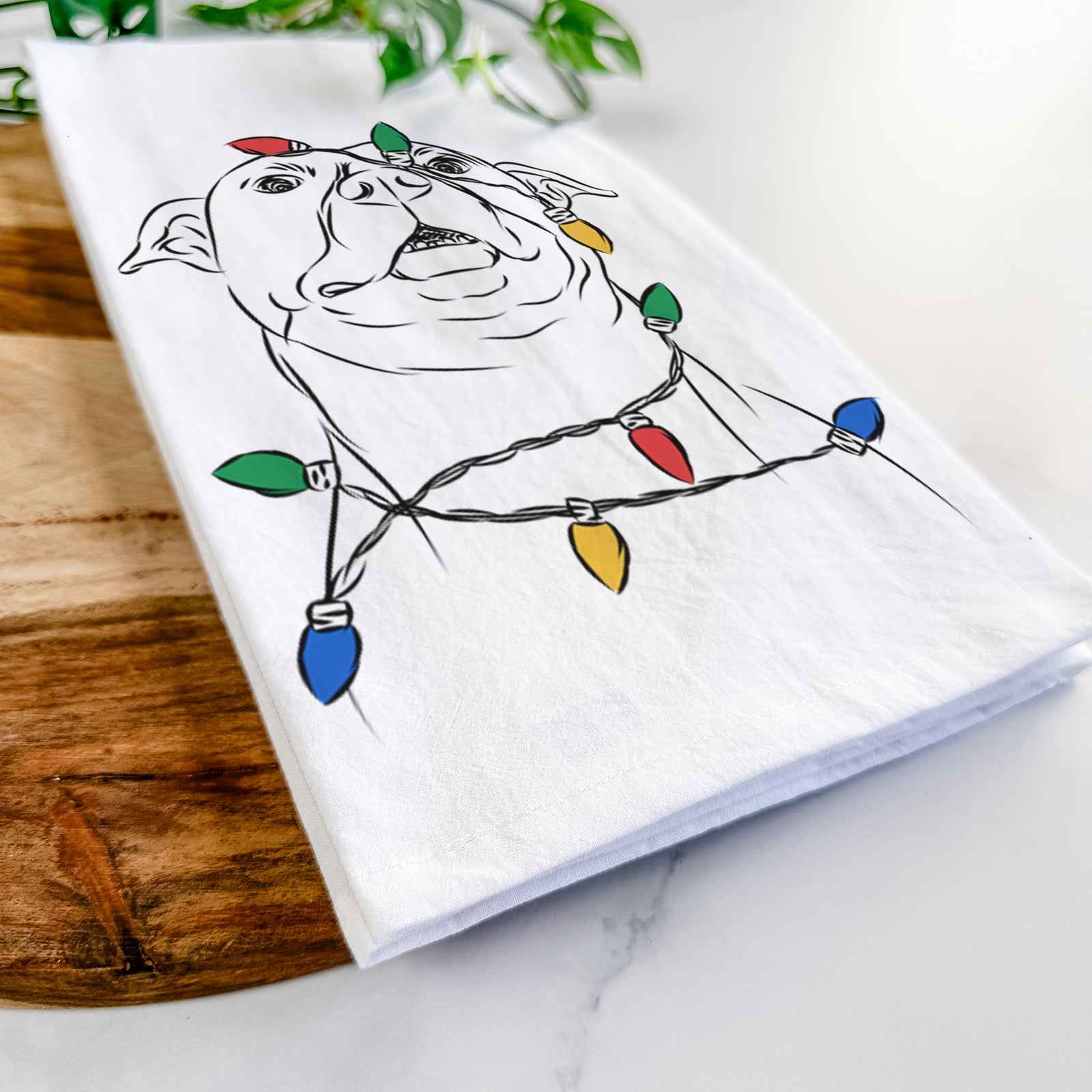 Hand-drawn sketch of Zada the Pitbull wrapped in Christmas lights on a tea towel