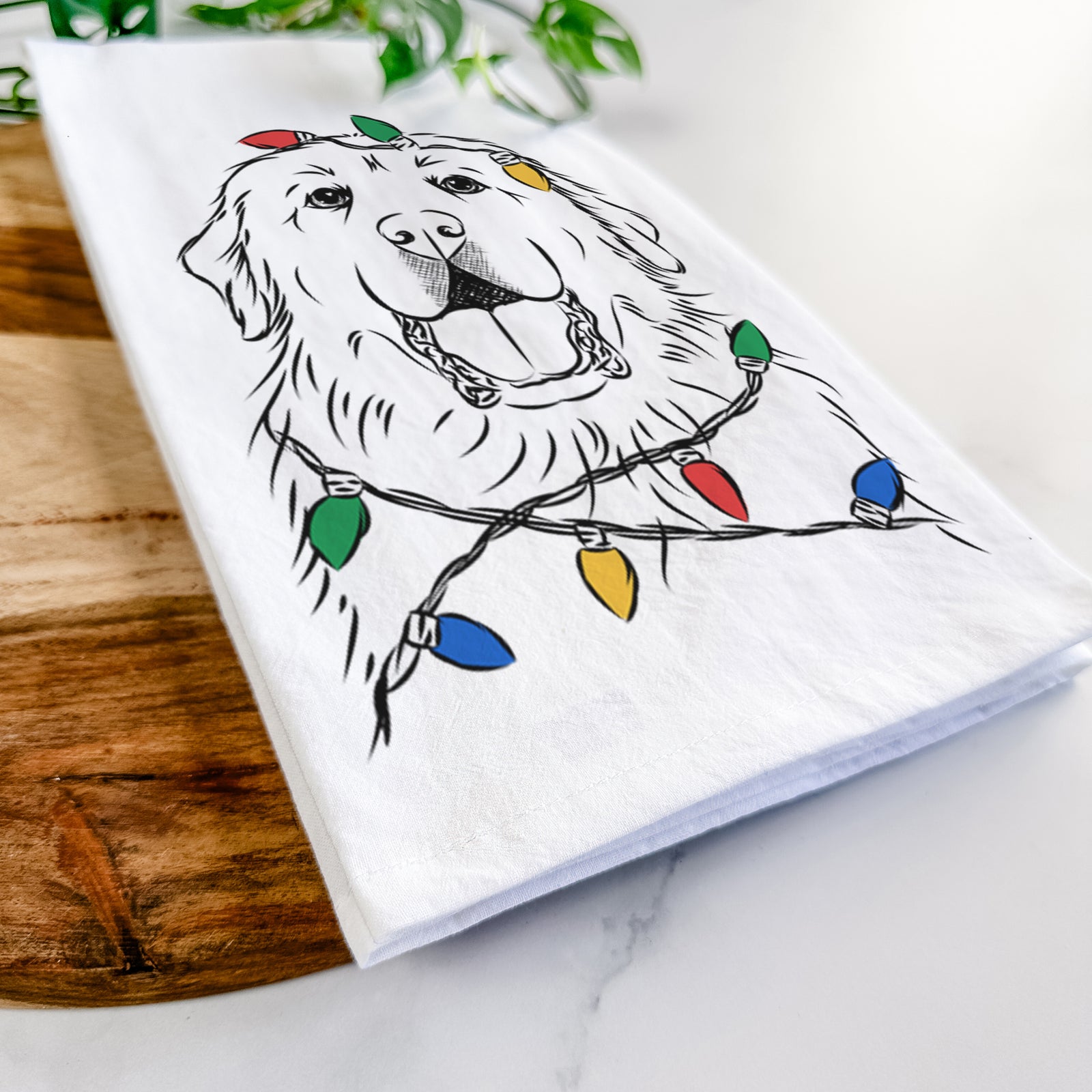 Hand-drawn sketch of Zeus the Great Pyrenees wrapped in Christmas lights on a tea towel
