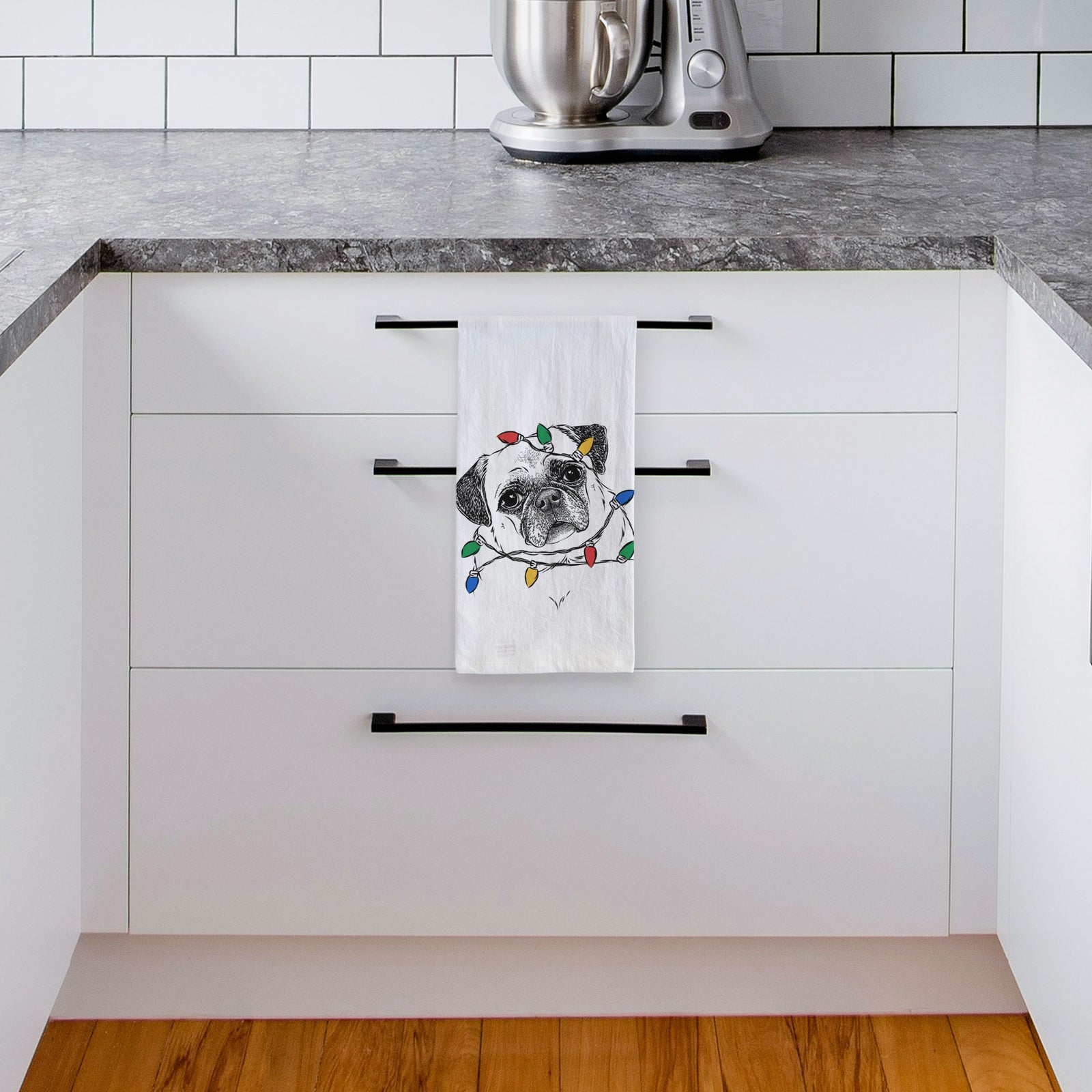 Hand-drawn sketch of Zoey the Pug wrapped in Christmas lights on a tea towel, hanging on an oven door in a kitchen