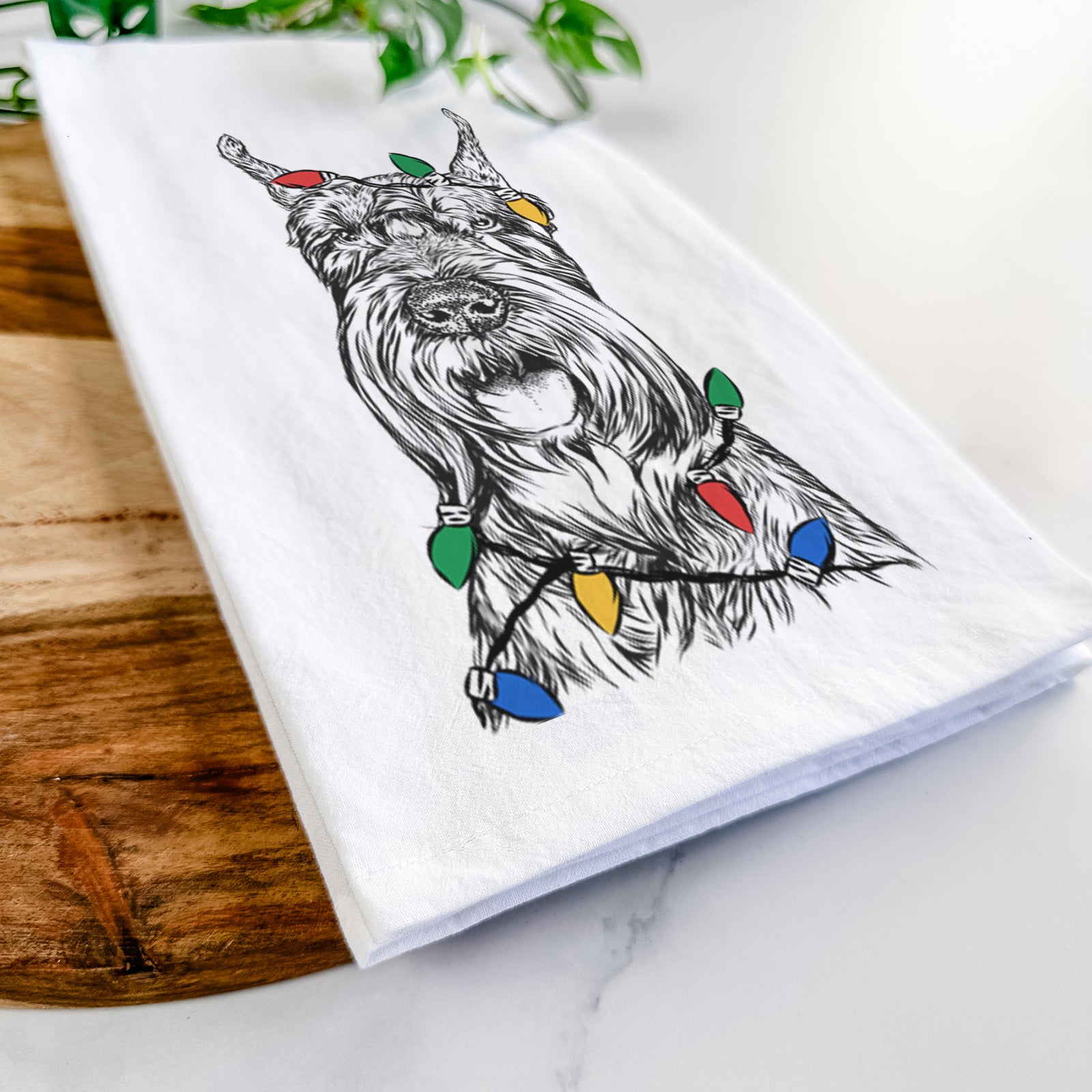 Hand-drawn sketch of Zuri the Giant Schnauzer wrapped in Christmas lights on a tea towel