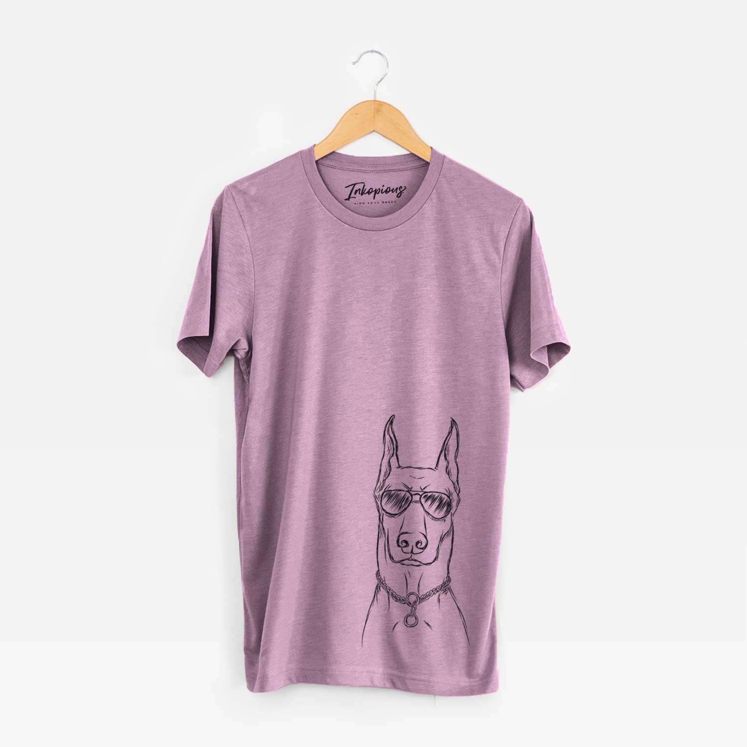 Hand-drawn sketch of Ace the Doberman Pinscher wearing aviator sunglasses on an Orchid Unisex crewneck