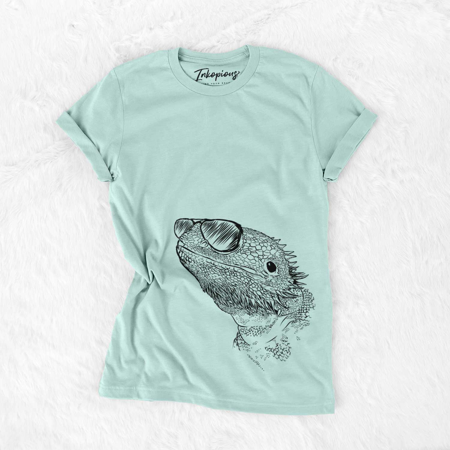 Hand-drawn sketch of Ash the Bearded Dragon wearing aviator sunglasses on a Heather Sage Unisex crewneck