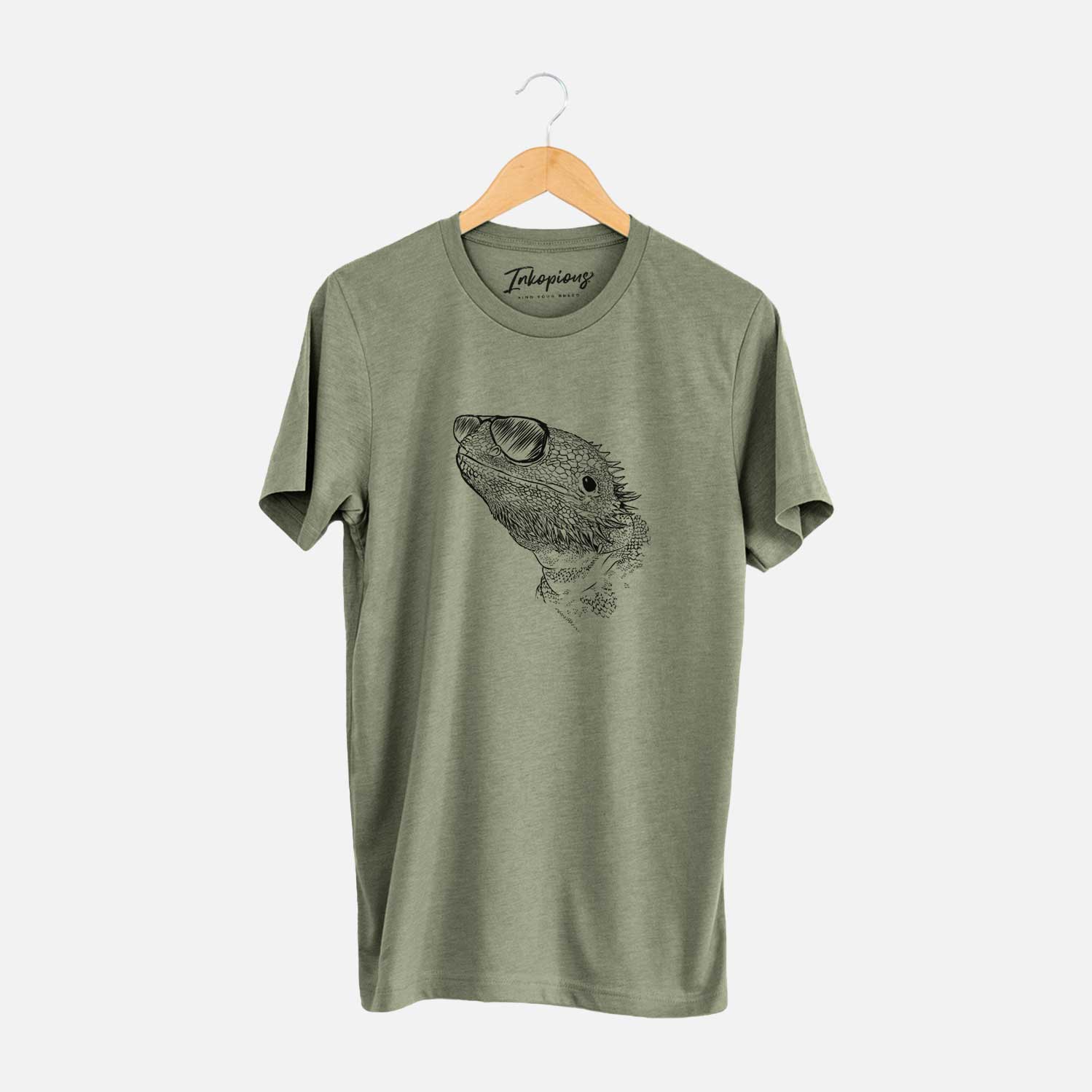 Hand-drawn sketch of Ash the Bearded Dragon wearing aviator sunglasses on an Olive Unisex crewneck