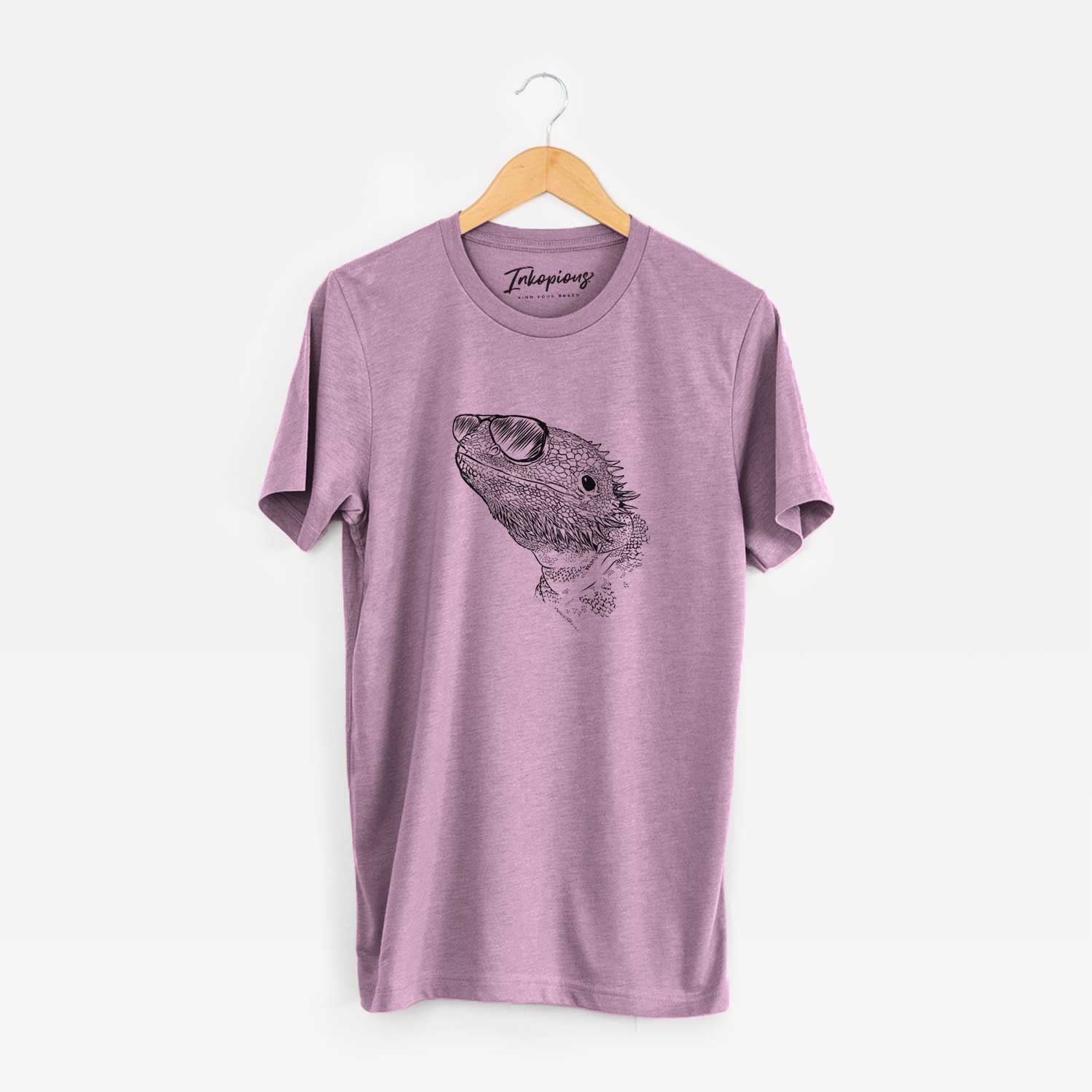 Hand-drawn sketch of Ash the Bearded Dragon wearing aviator sunglasses on an Orchid Unisex crewneck