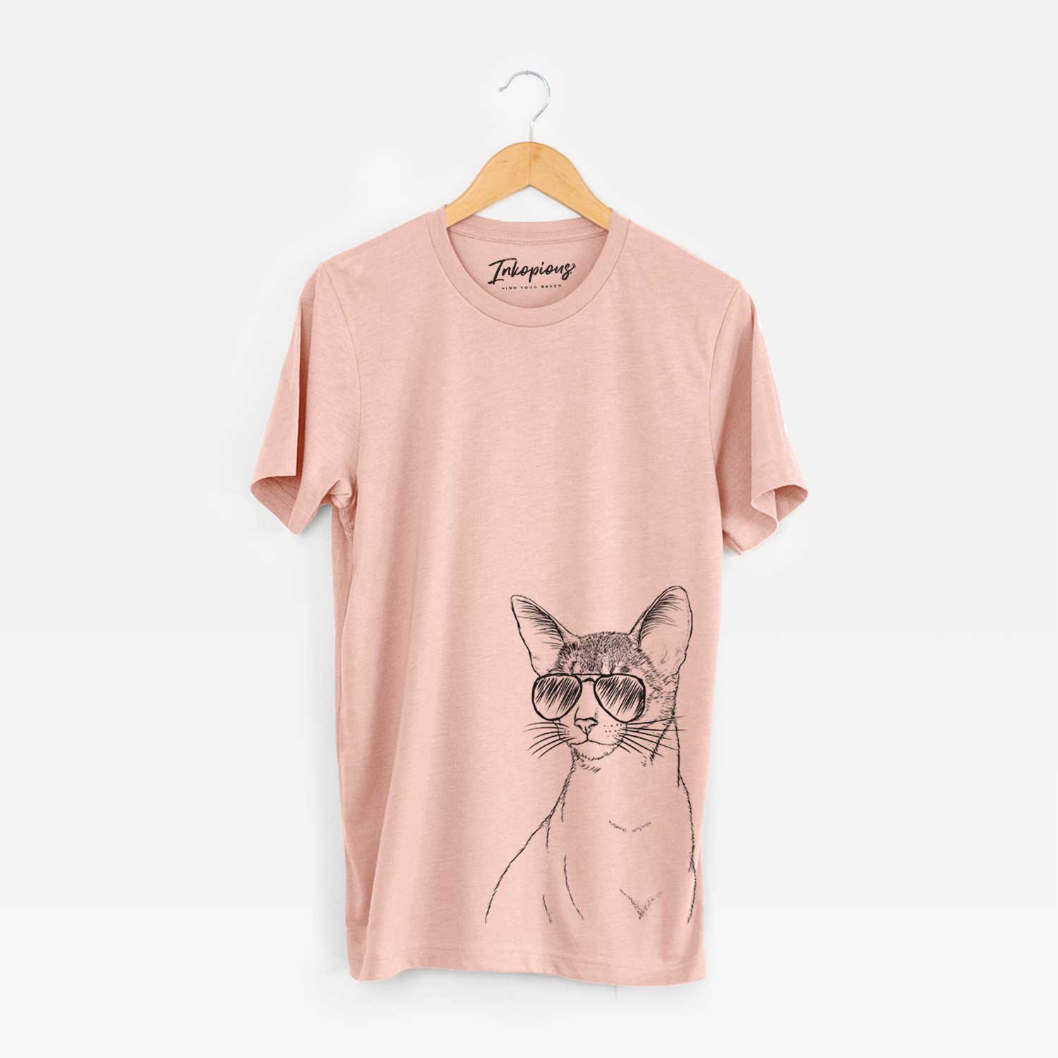 Hand-drawn sketch of Cedric the Abyssinian Cat wearing aviator sunglasses on a Peach Bella Canvas Unisex Crewneck