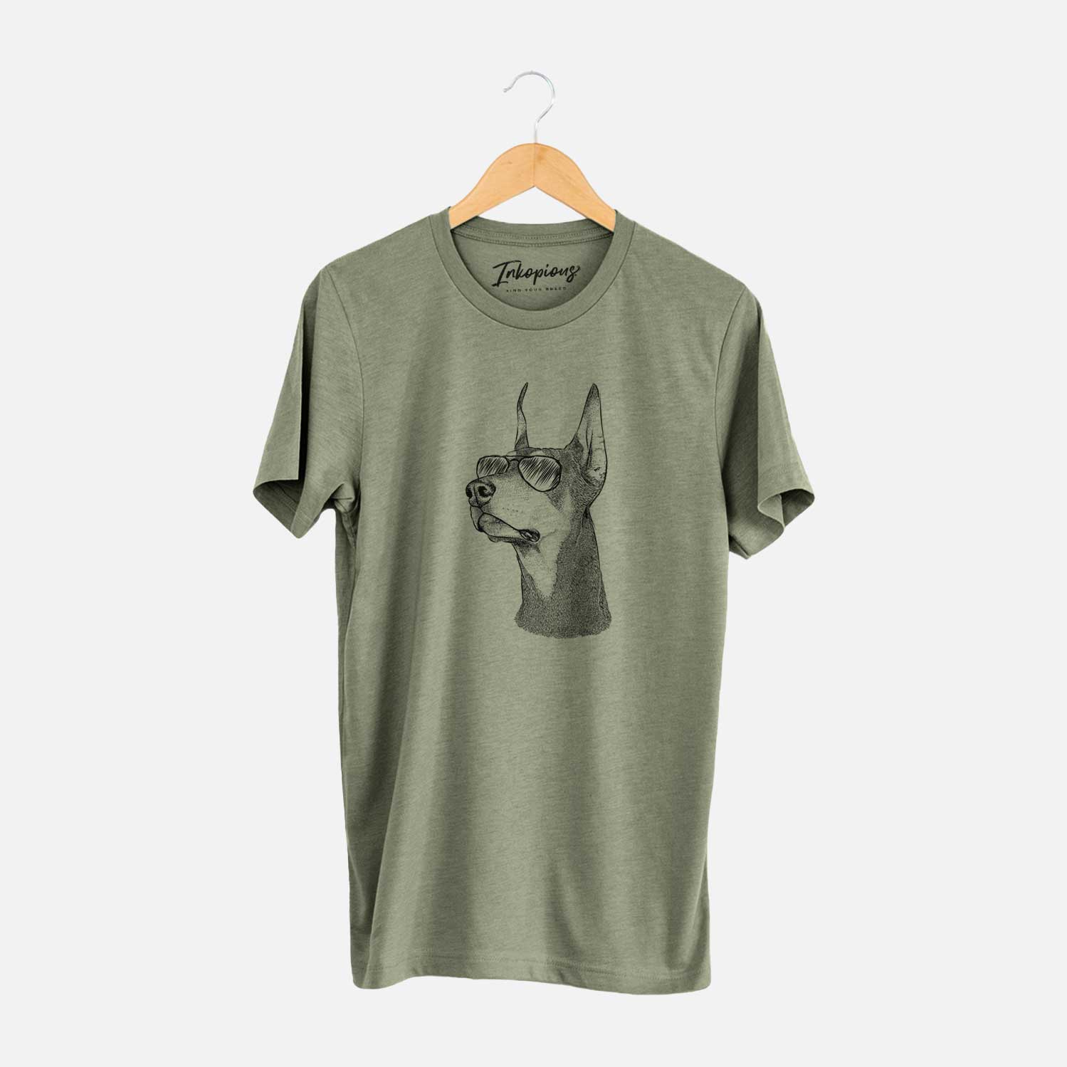 Hand-drawn sketch of Cenza the Doberman Pinscher wearing aviator sunglasses on an Olive Unisex crewneck