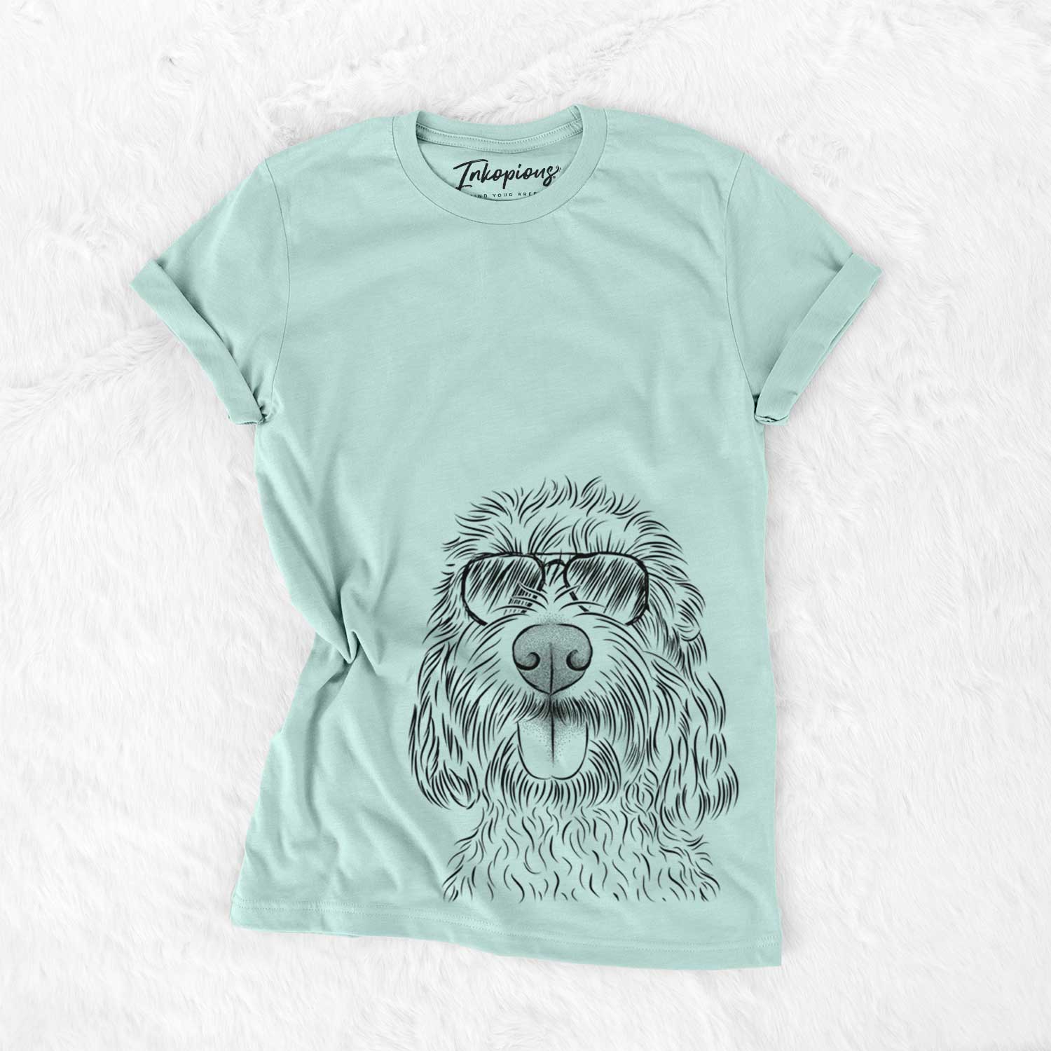 Hand-drawn sketch of Clover the Cockapoo wearing aviator sunglasses on a Heather Sage Unisex crewneck