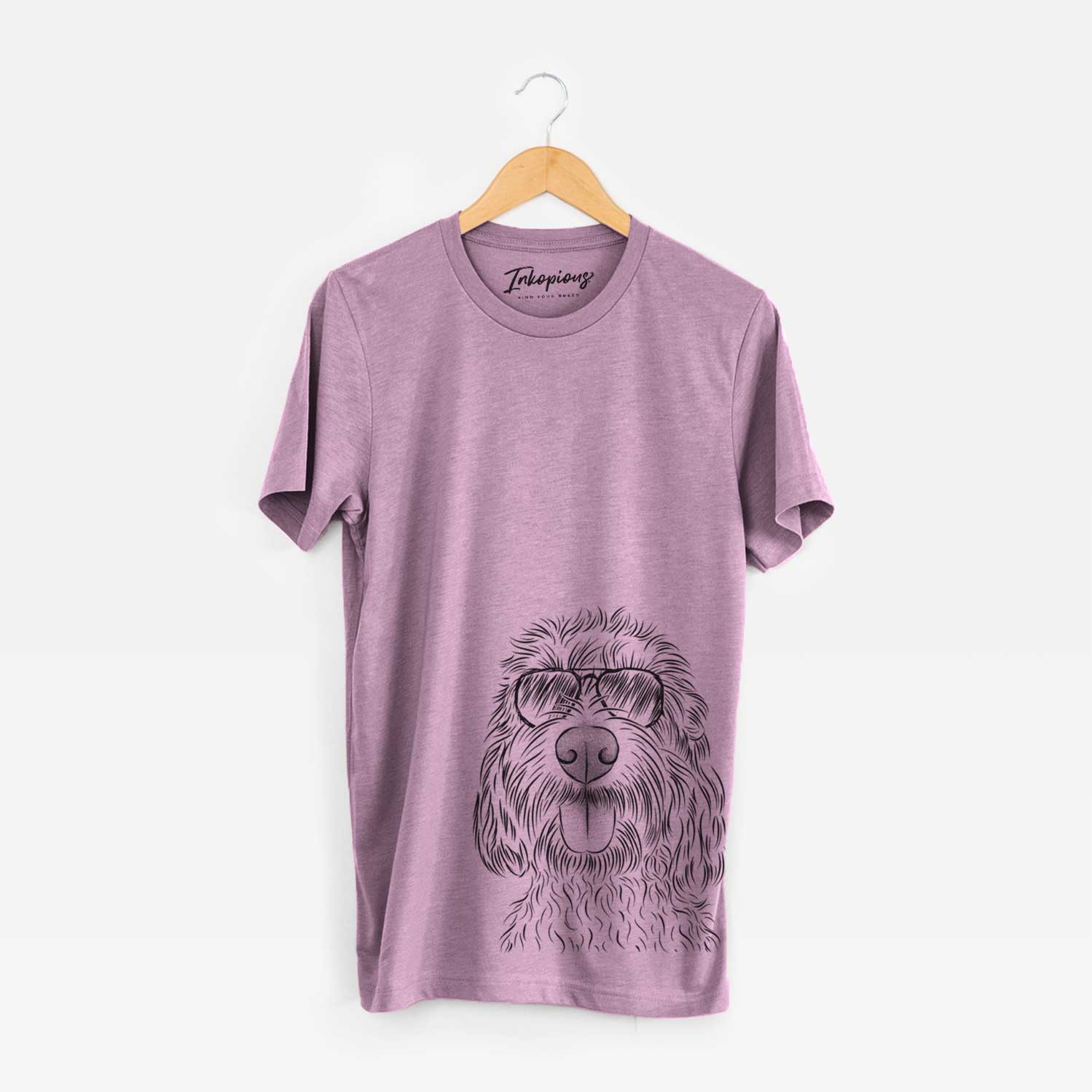 Hand-drawn sketch of Clover the Cockapoo wearing aviator sunglasses on an Orchid Unisex crewneck