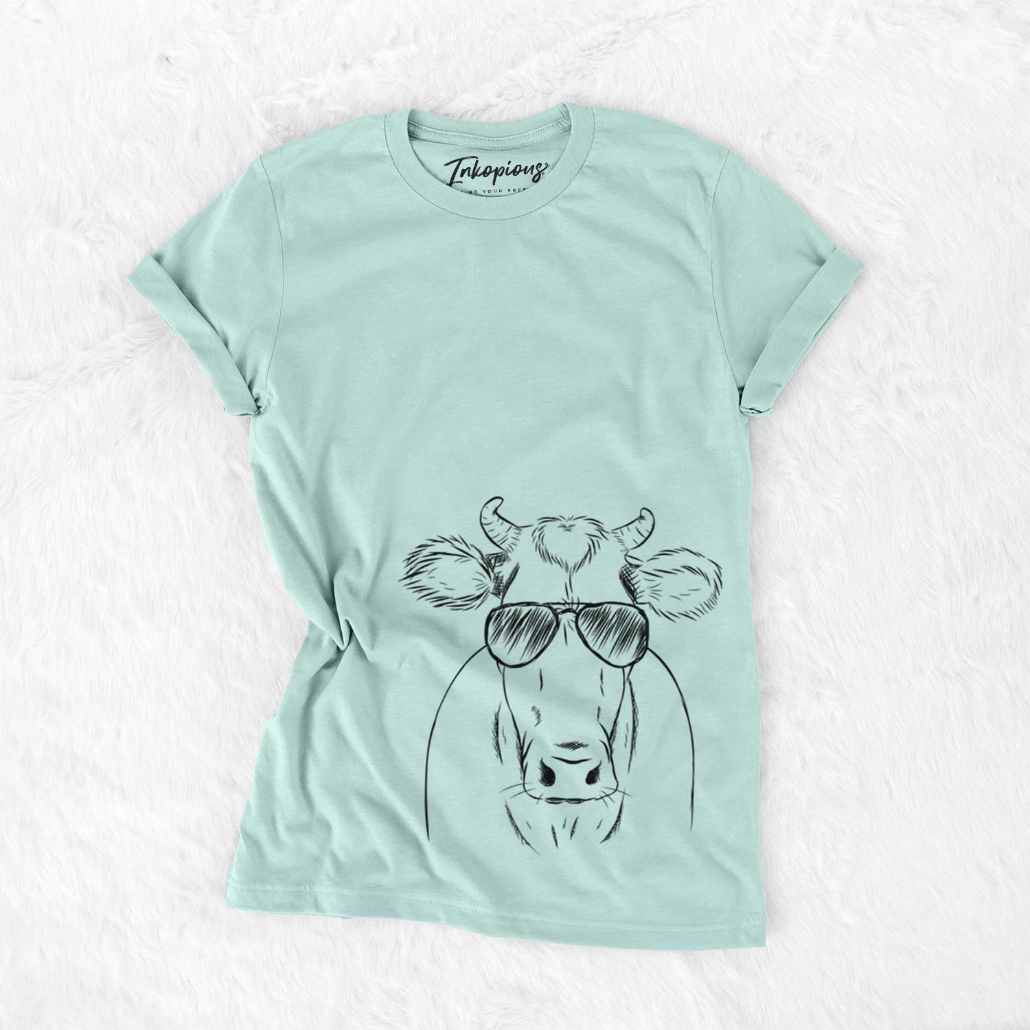 Hand-drawn sketch of Cruz the Cow wearing aviator sunglasses on a Heather Sage Unisex crewneck