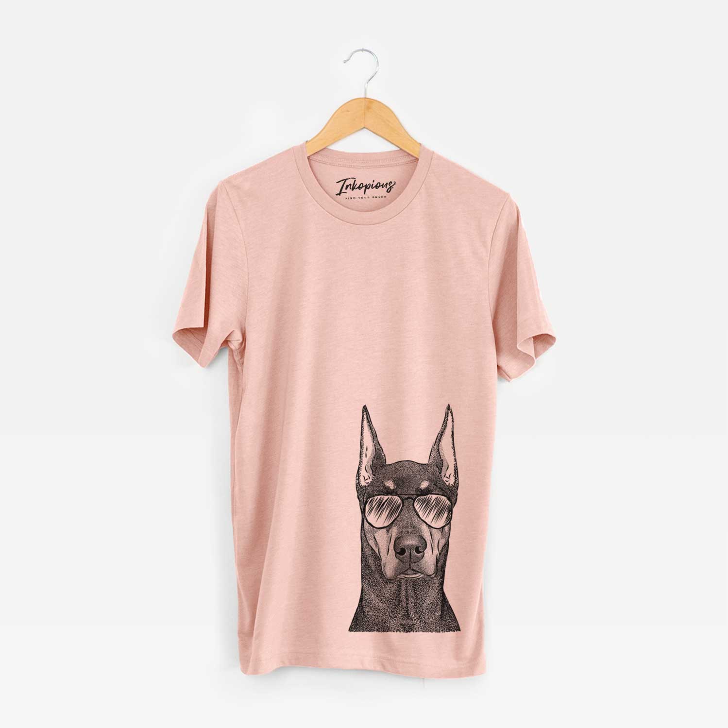 Hand-drawn sketch of Drake the Doberman Pinscher wearing aviator sunglasses on a Peach Unisex crewneck