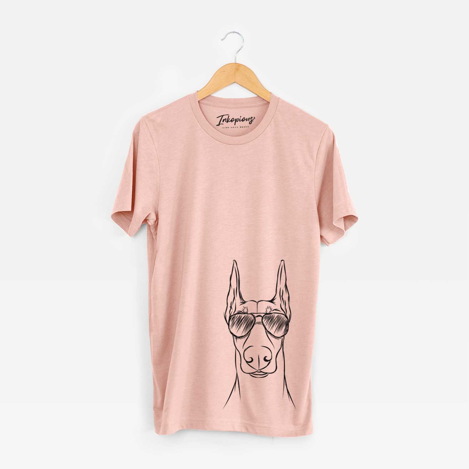 Hand-drawn sketch of Duke the Doberman Pinscher wearing aviator sunglasses on a Peach Unisex crewneck