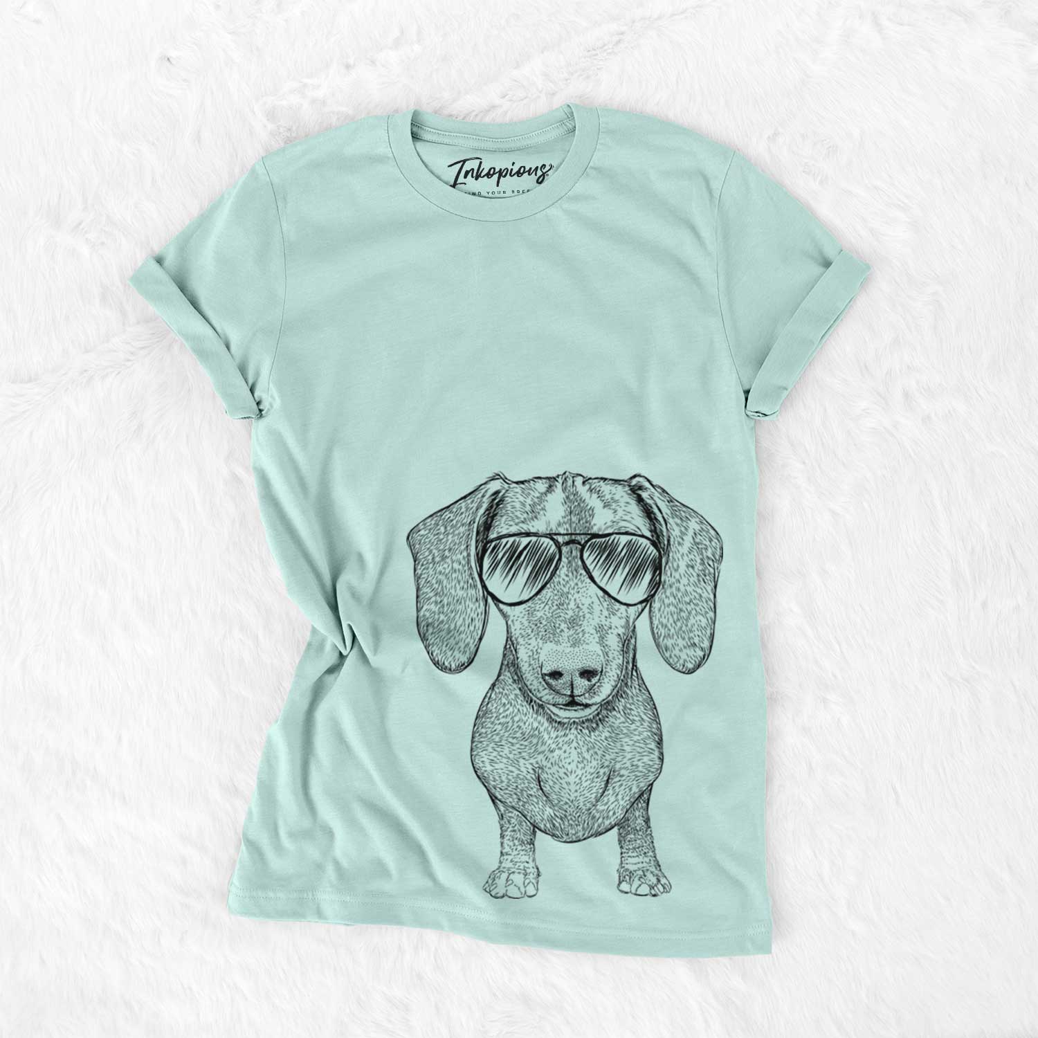 Hand-drawn sketch of Ernie the Mini Dachshund wearing aviator sunglasses on a Heather Sage Unisex crewneck