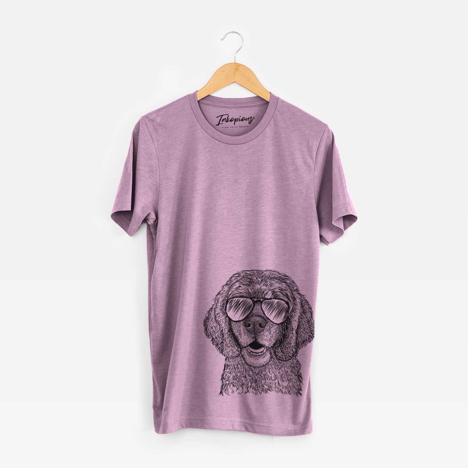 Hand-drawn sketch of Fannie Mae the Cocker Spaniel wearing aviator sunglasses on an Orchid Unisex crewneck