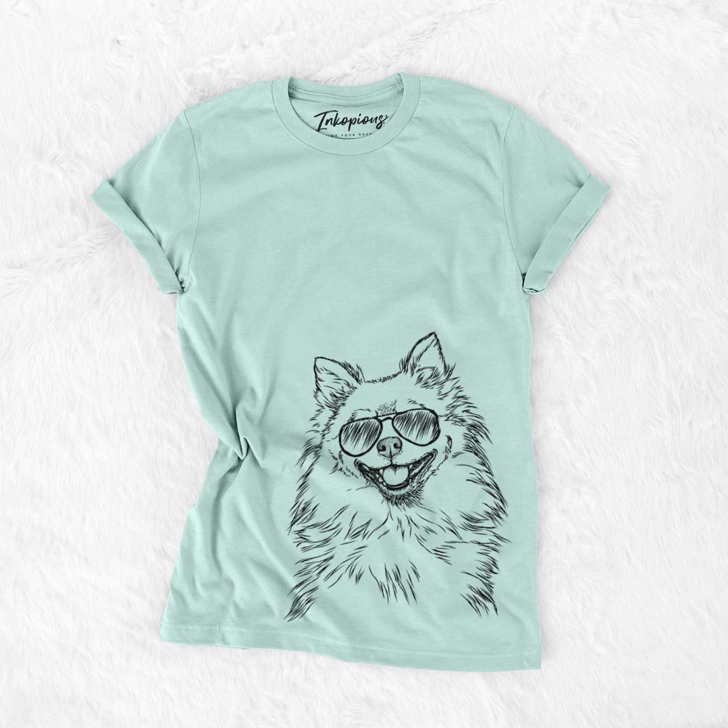 Hand-drawn sketch of Fibi the Spitz wearing aviator sunglasses on a Heather Sage Unisex crewneck